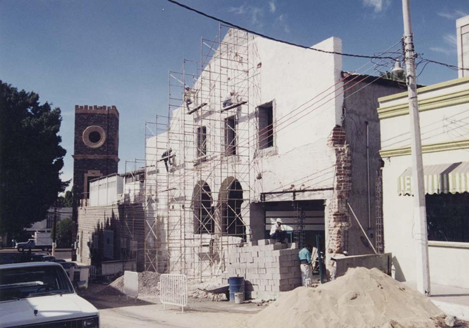 Hombres que remodelan la fachada del teatro Juárez.