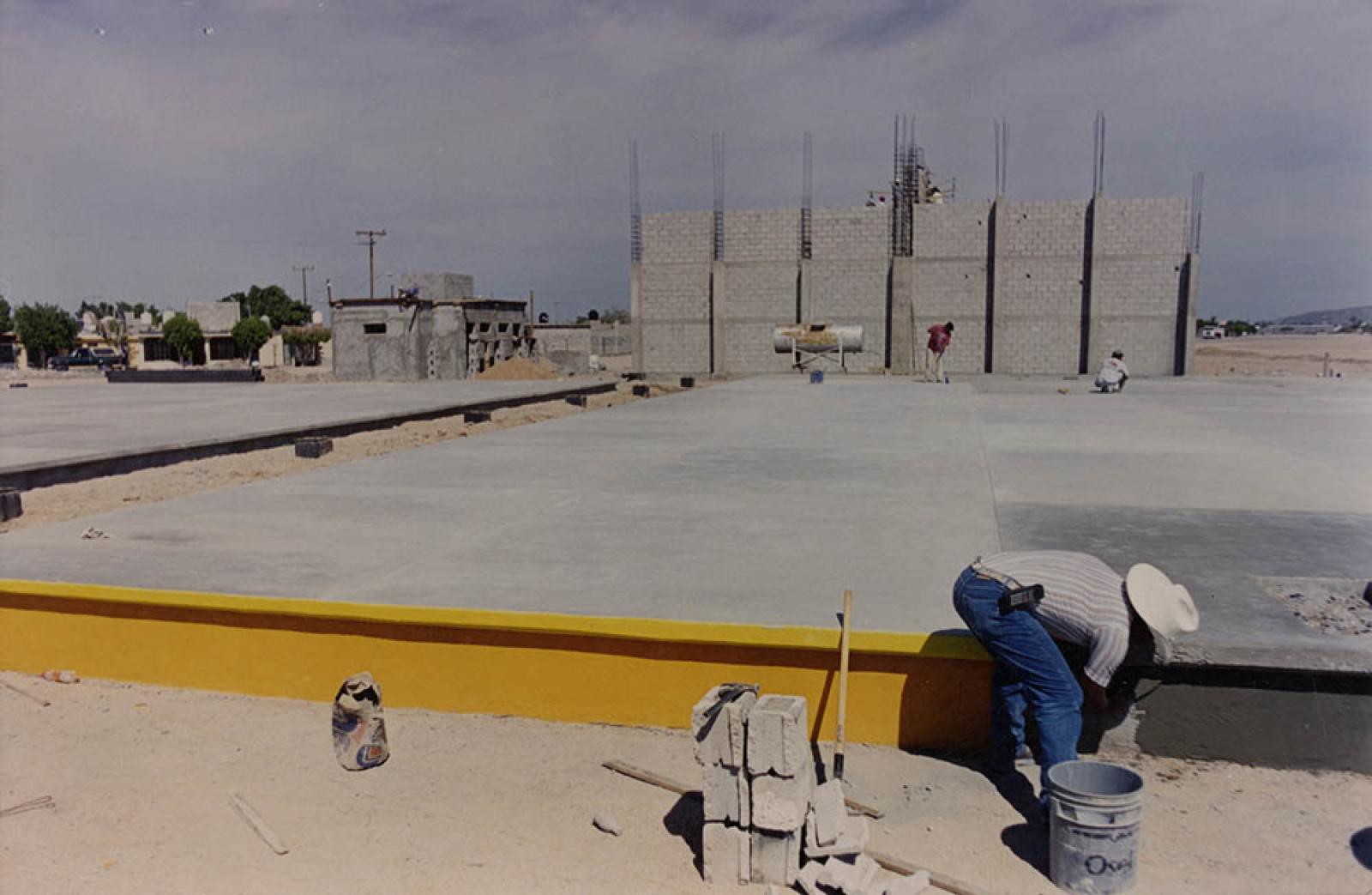 Hombres que trabajan en la construcción de la Unidad Deportiva Estudiantil.