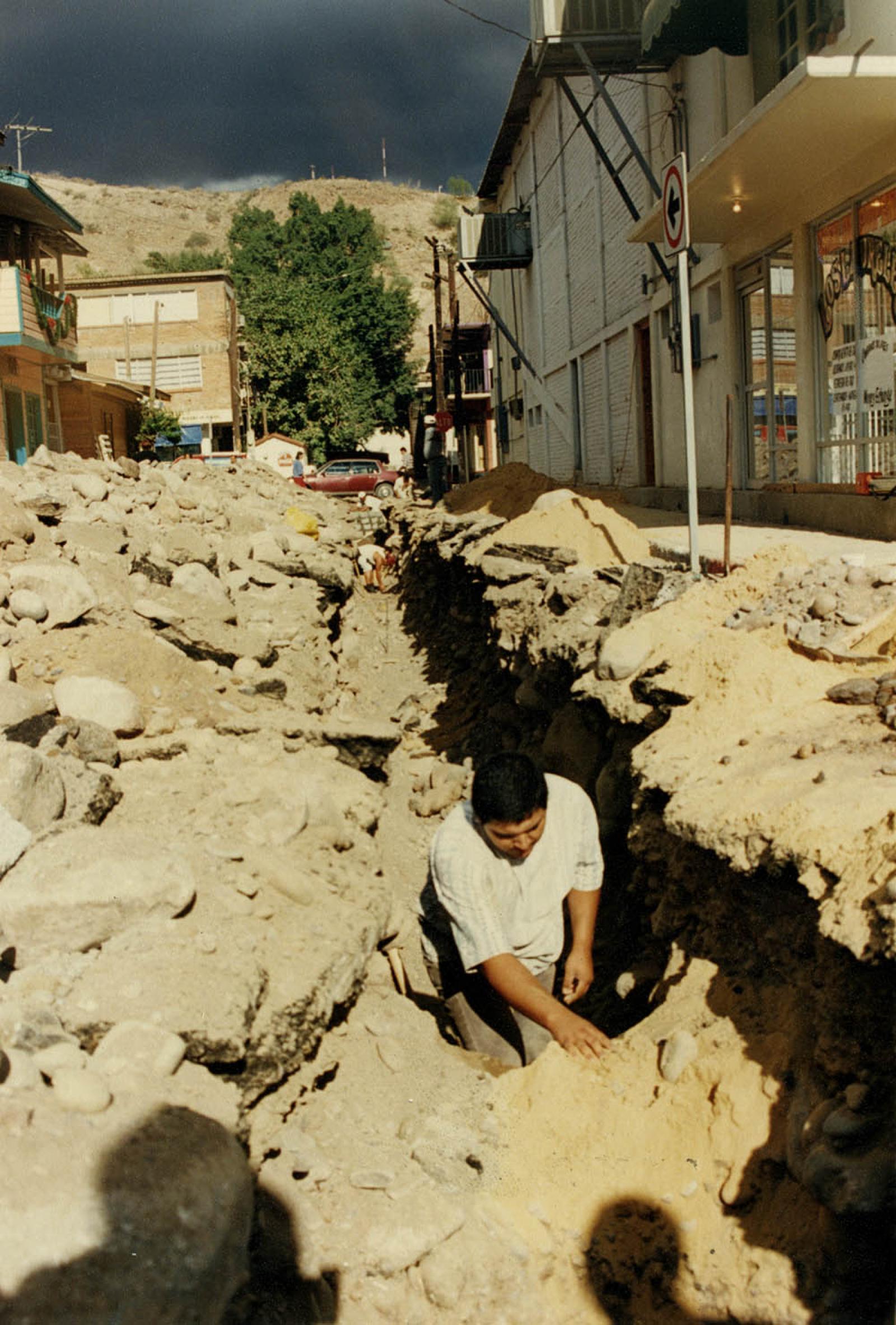 Hombres realizan obra pública en calle.