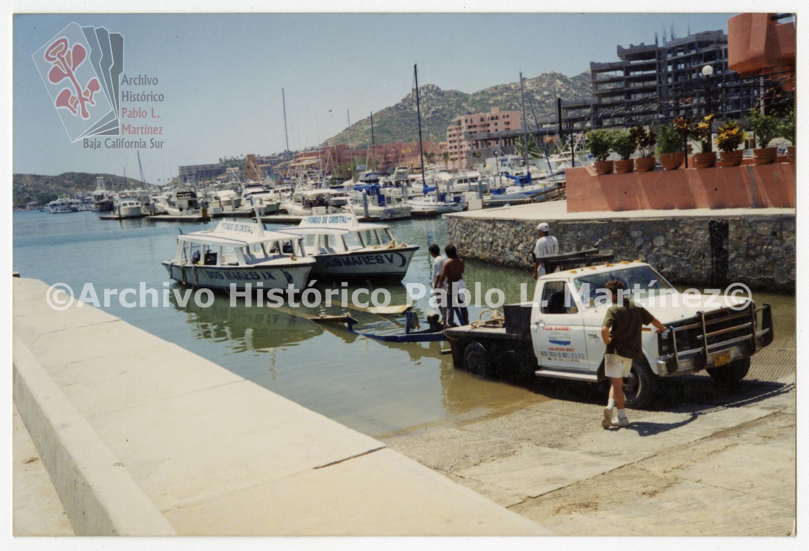 Hombres sacan pangas del mar utilizando una camioneta, marina de Cabo San Lucas, Baja California Sur.