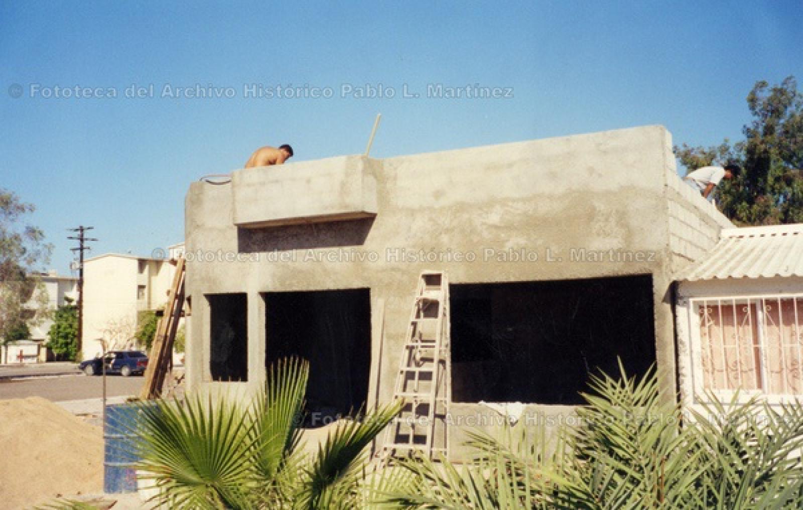 Hombres sobre techo de obra en construcción.