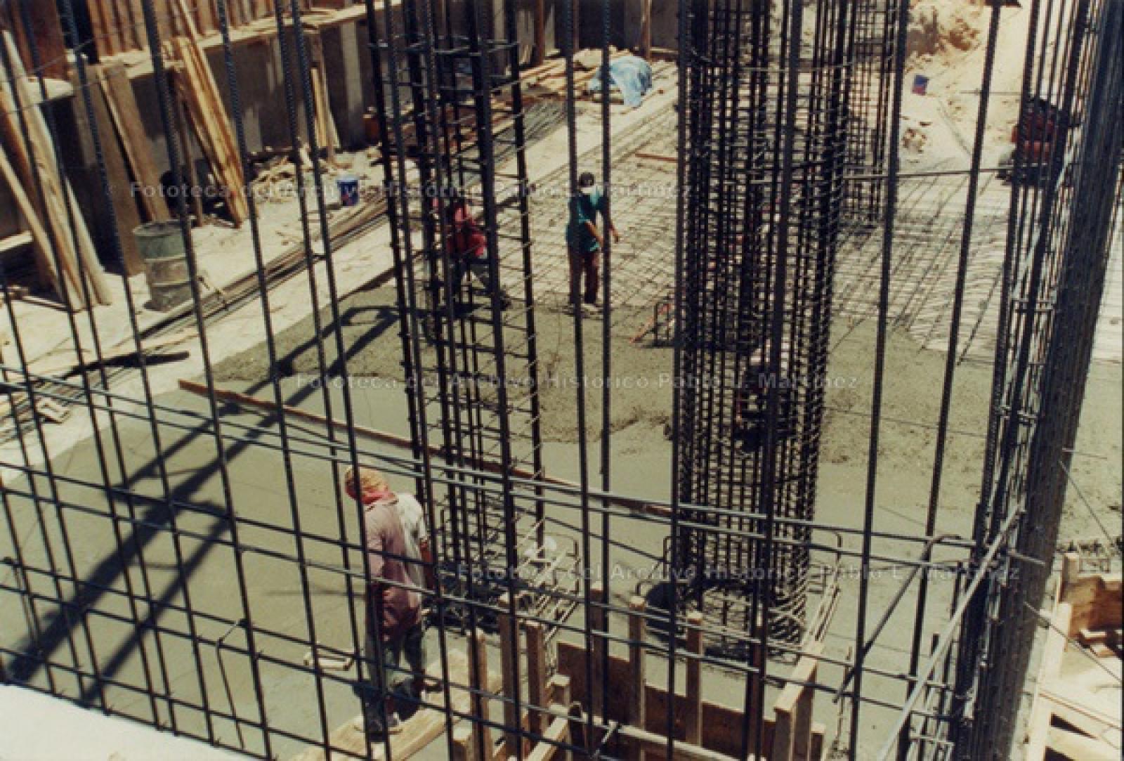 Hombres trabajan en construcción de edificio.