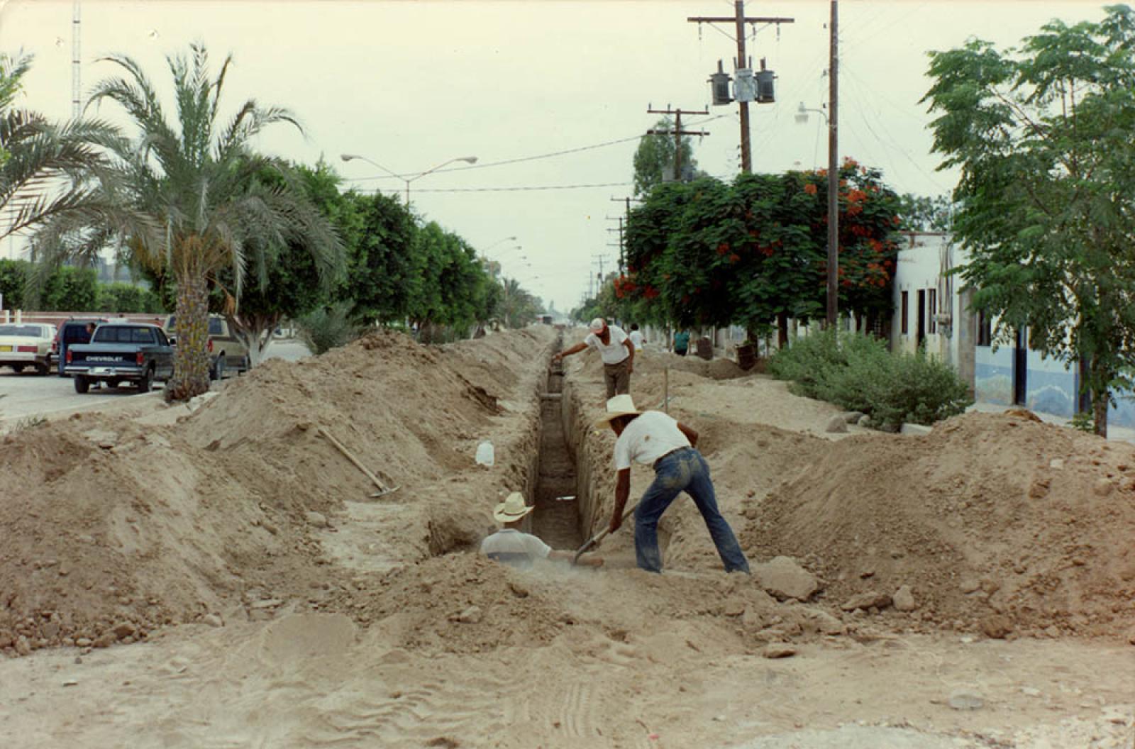 Hombres trabajan en obra pública en la calle Francisco I. Madero.