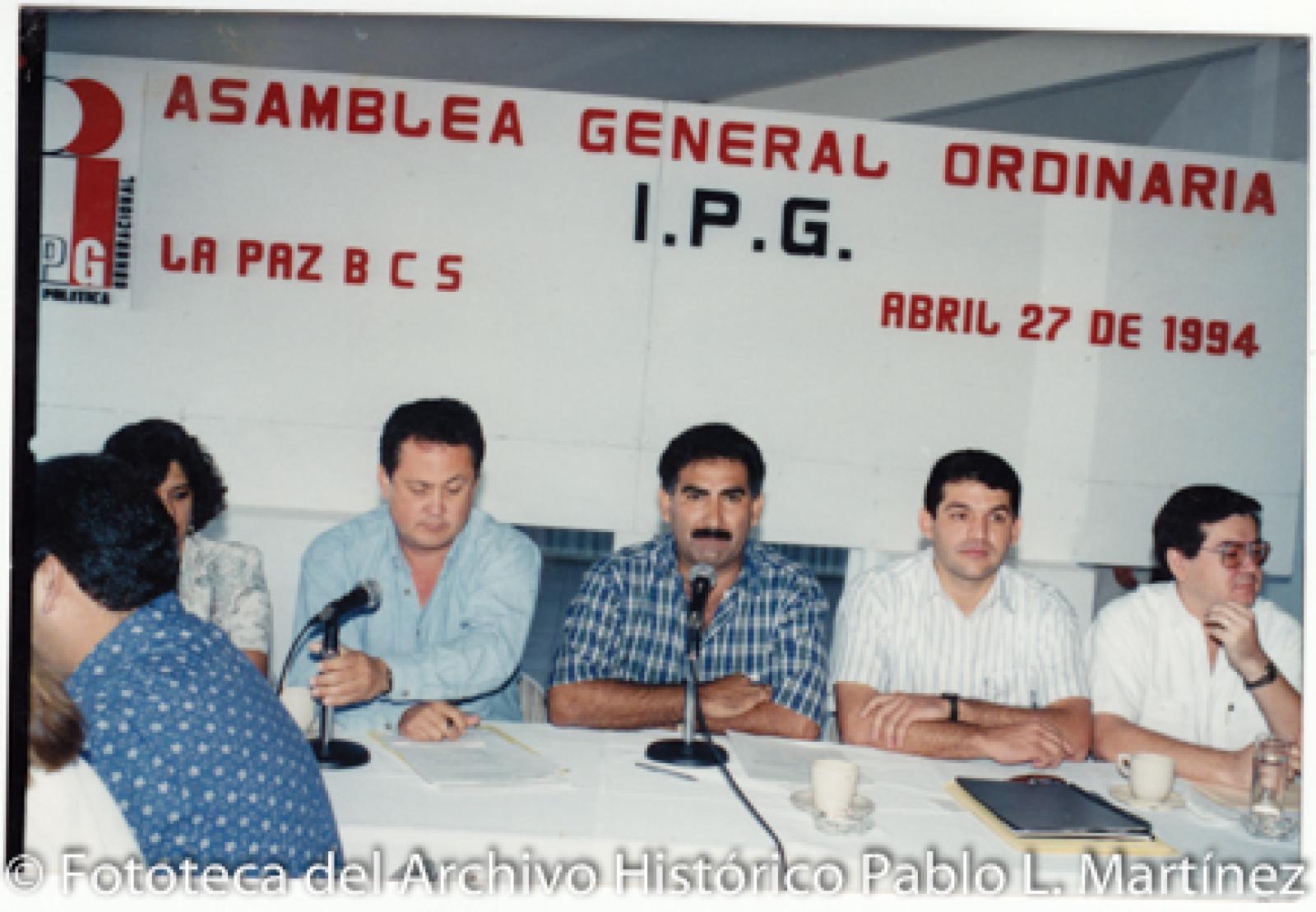Hombres y mujer en asamblea.