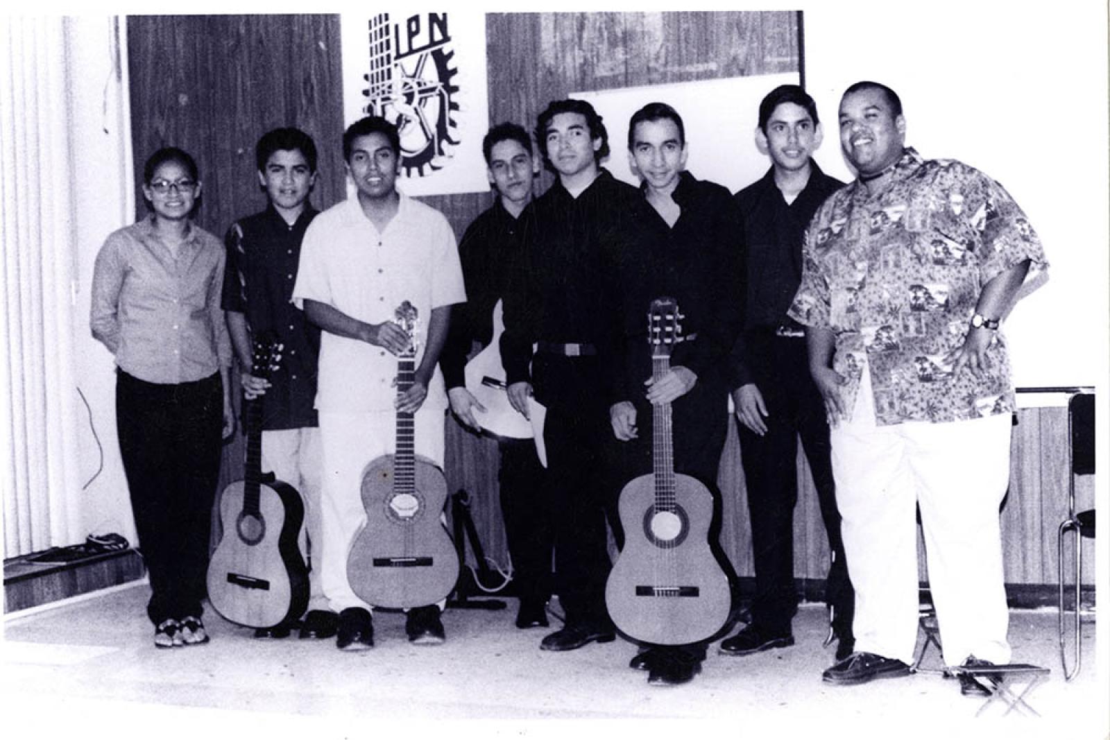 Hombres y mujer en salón, retrato de grupo.