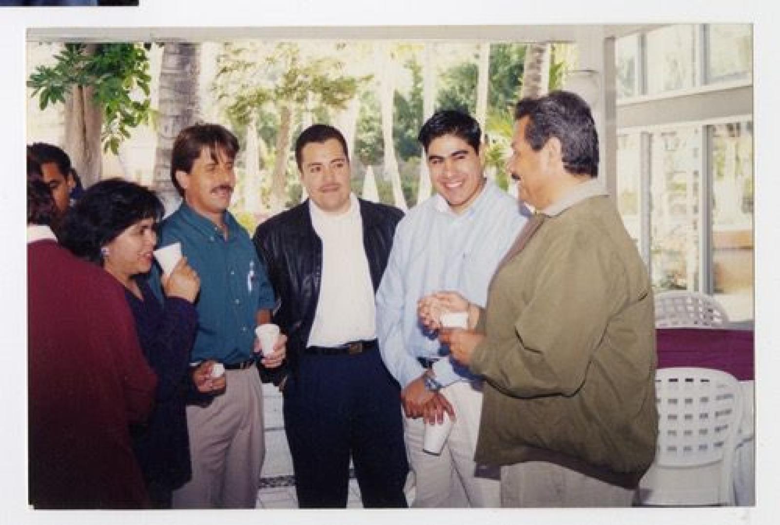 Hombres y mujer reunidos en platica.