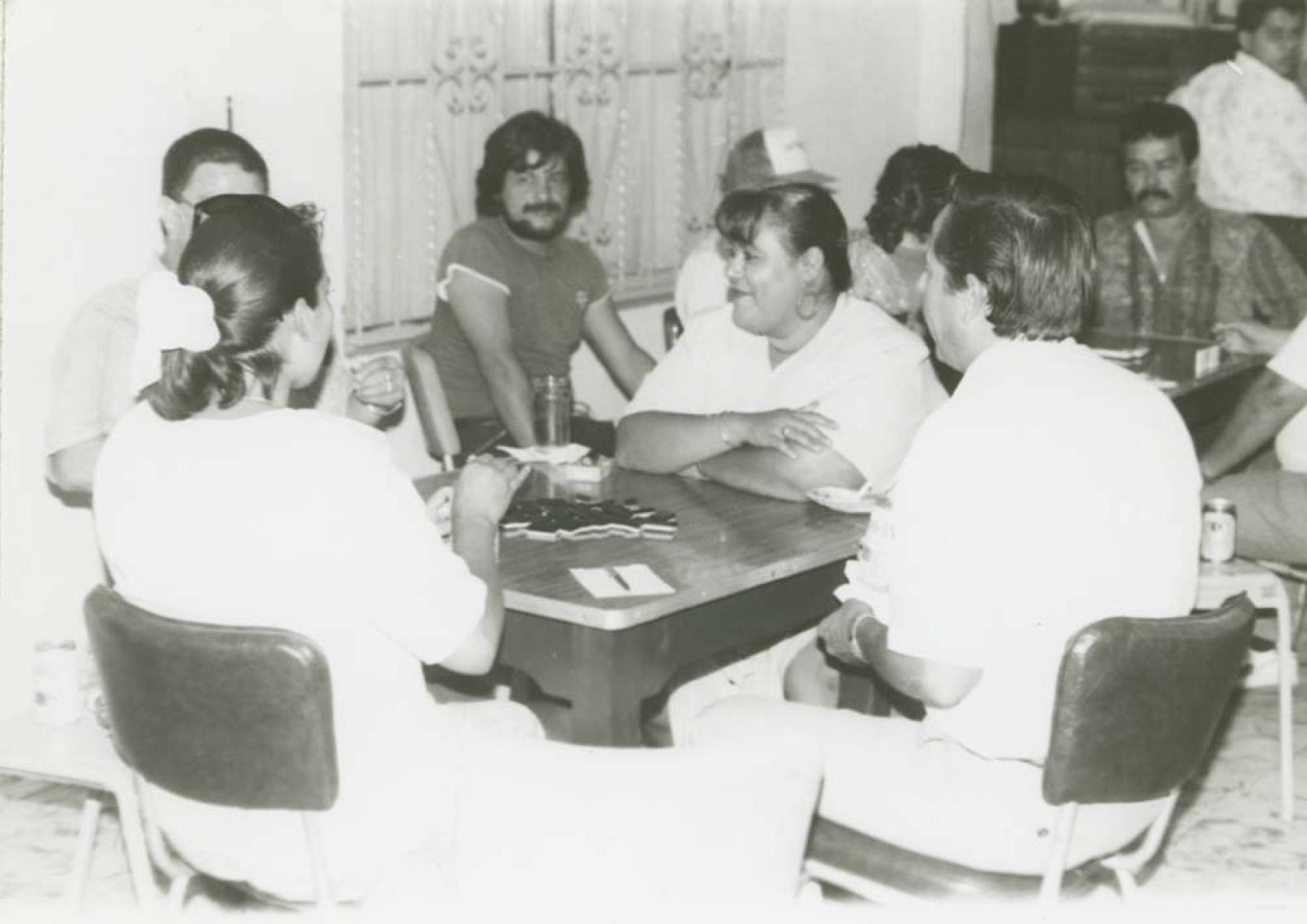 Hombres y mujeres en juego de dominó.