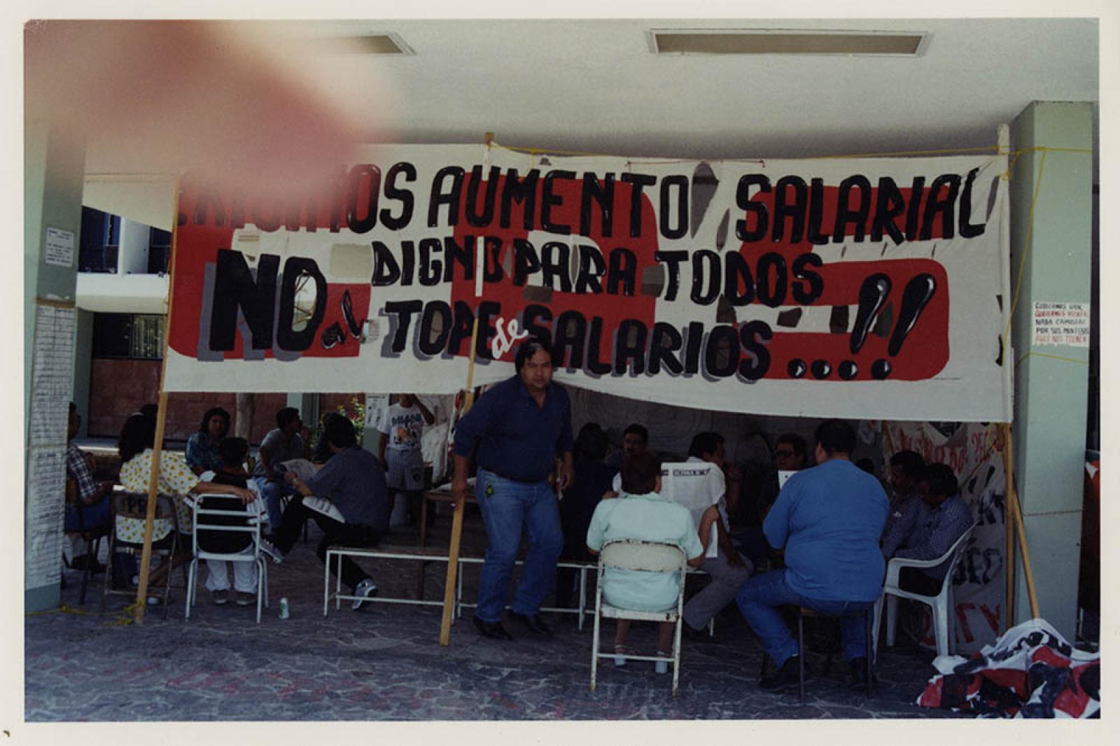 Hombres y mujeres en plantón. Exigen aumento de salarial.
