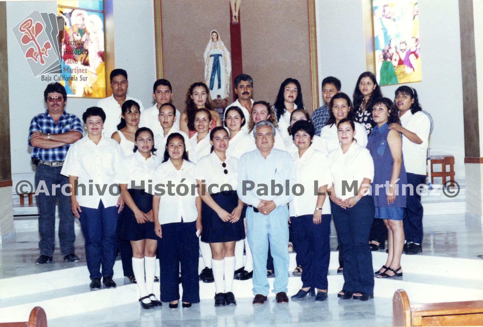 Hombres y mujeres posan frente al altar del templo de Nuestra Señora de Lourdes en Constitución Baja California Sur. Retrato de grupo.