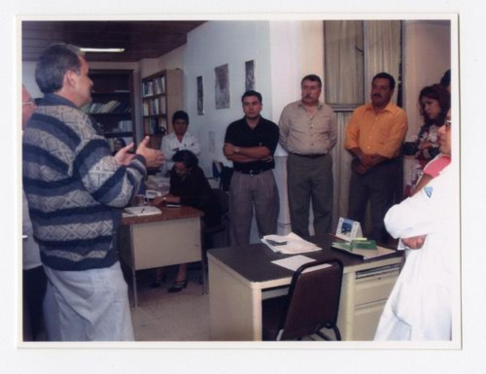 Hombres y mujeres reunidos en oficina.