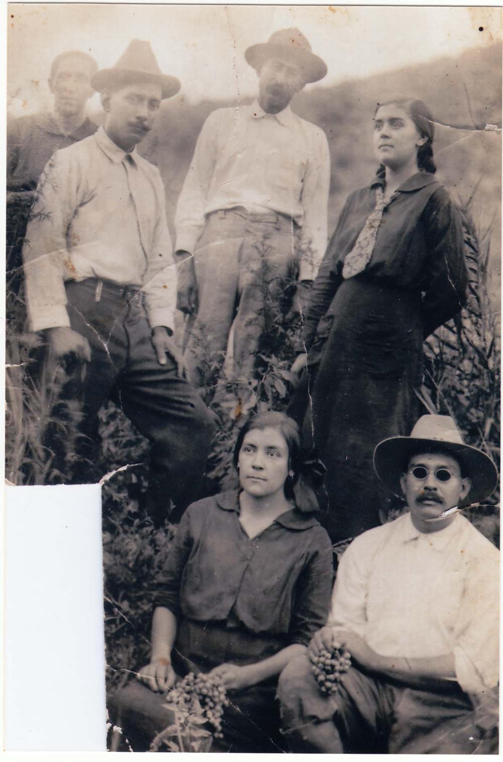Hombres y mujeres rodeados de vegetación.