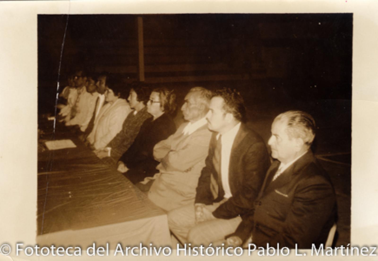 Hombres y mujeres sentados frente a mesa