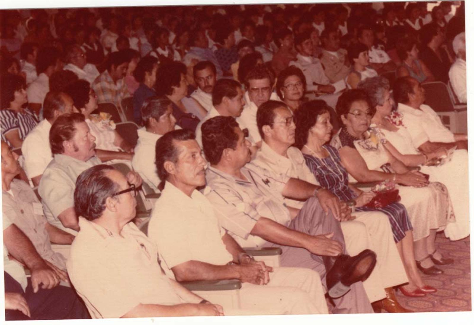Hombres y mujeres, vista panorámica en auditorio.