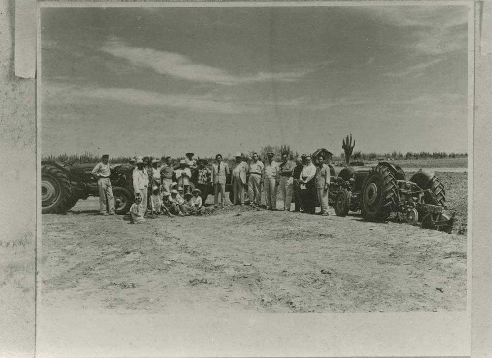 Hombres y niños con maquinaria agrícola.