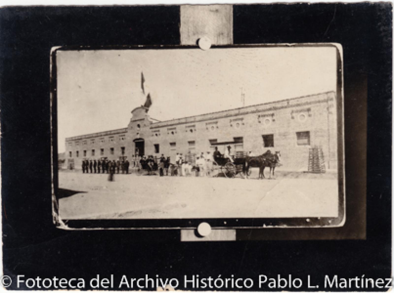 Hombres y niños frente a edificio.