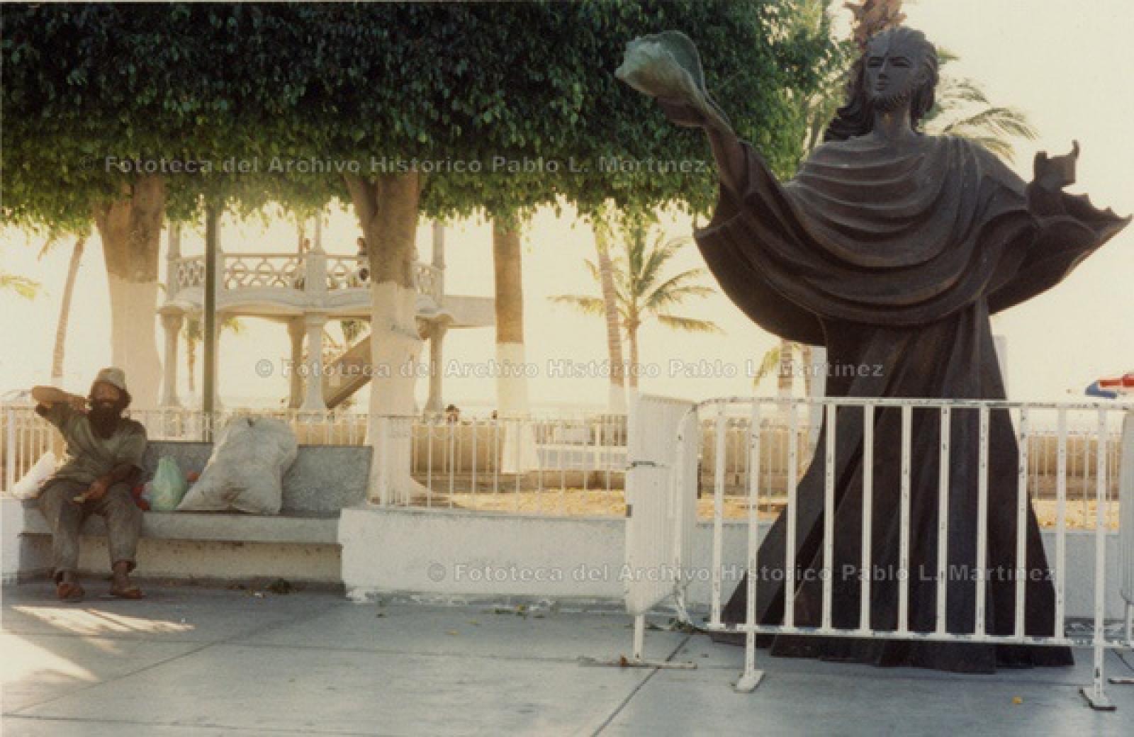 Indigente señala al monumento cercado El Cristo del Caracol, en parque del kiosco del malecón.
