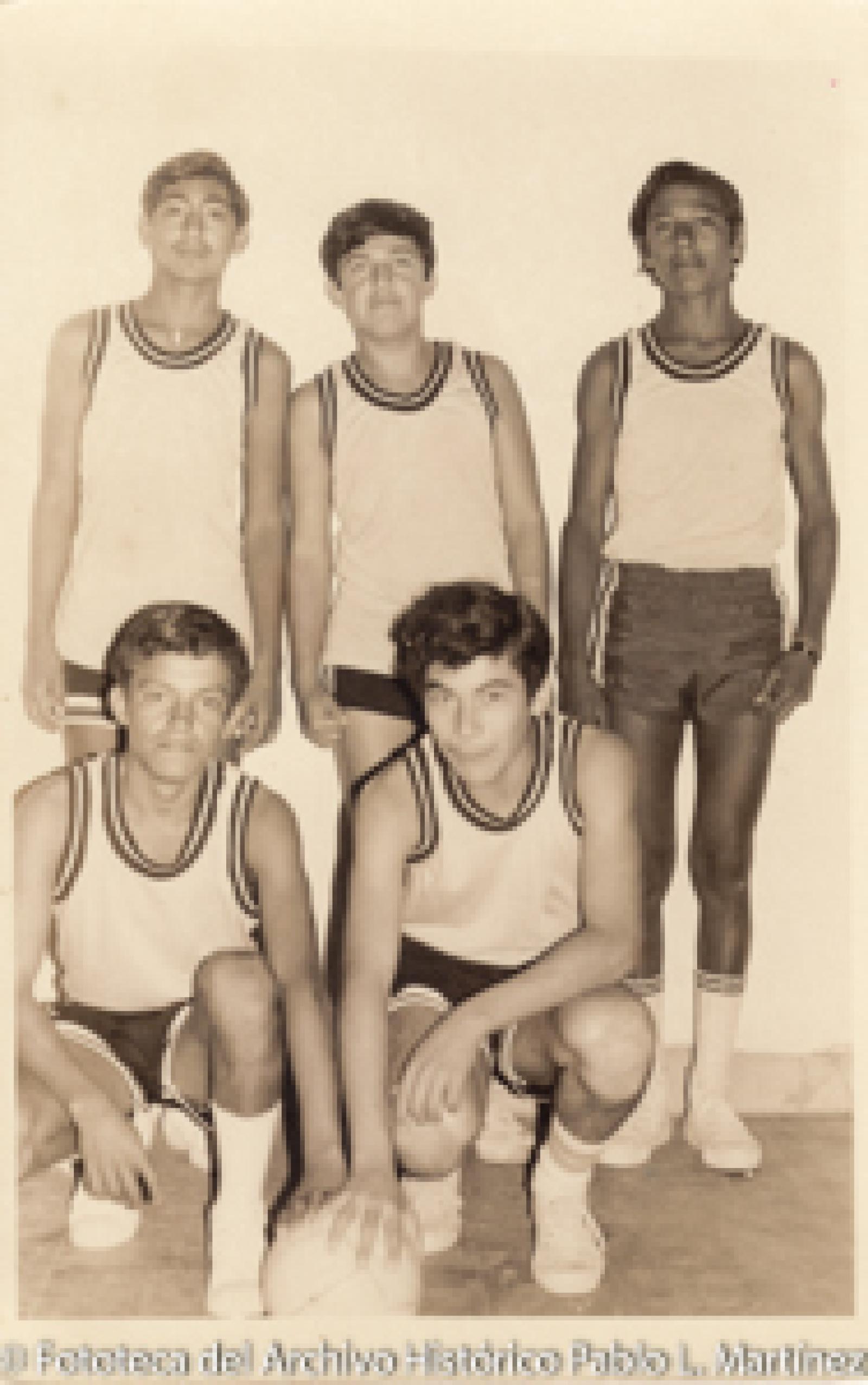 Jóvenes con uniformes deportivo y balón de voleibol.