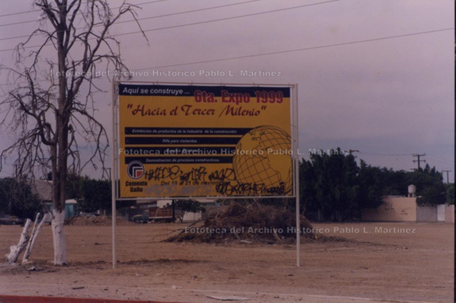Letrero en terreno baldío que anuncia la “6 Expo 1999, Hacia el Tercer Milenio”.