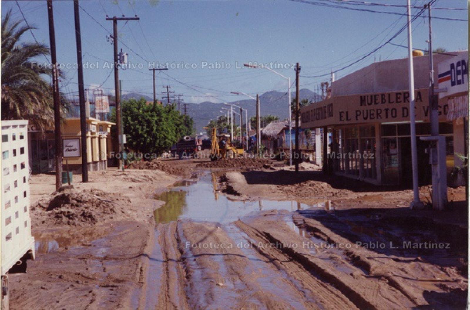 Maquinaria en calle sin encarpetar y con encharcamientos.
