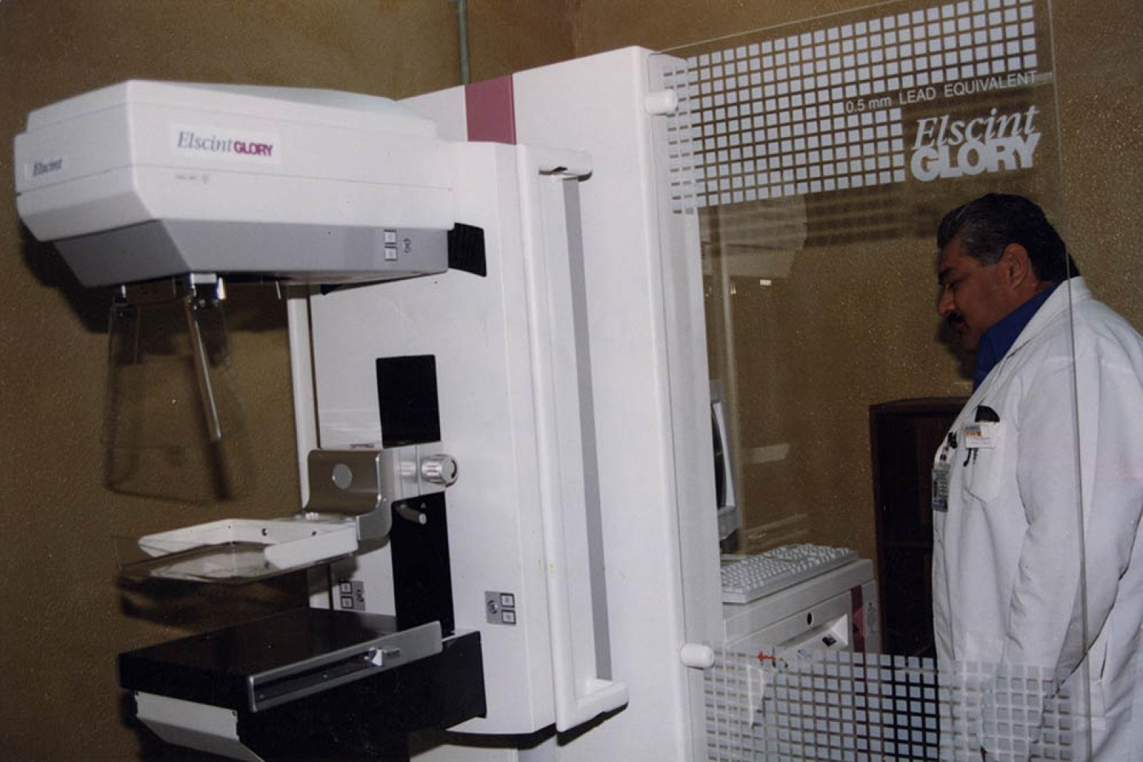 Médico frente a equipo de mamografía.