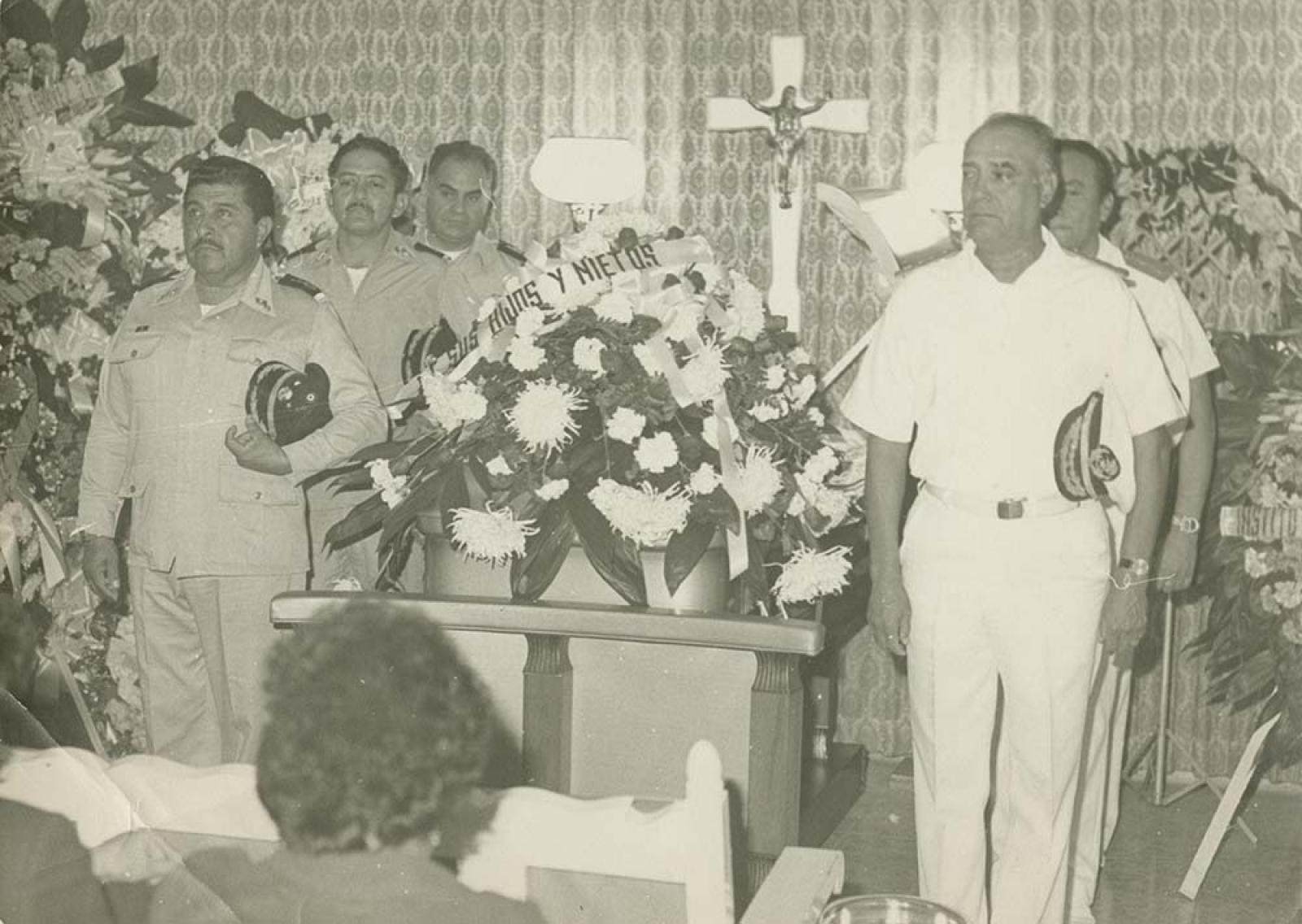 Militares hacen guardia de honor frente a féretro.