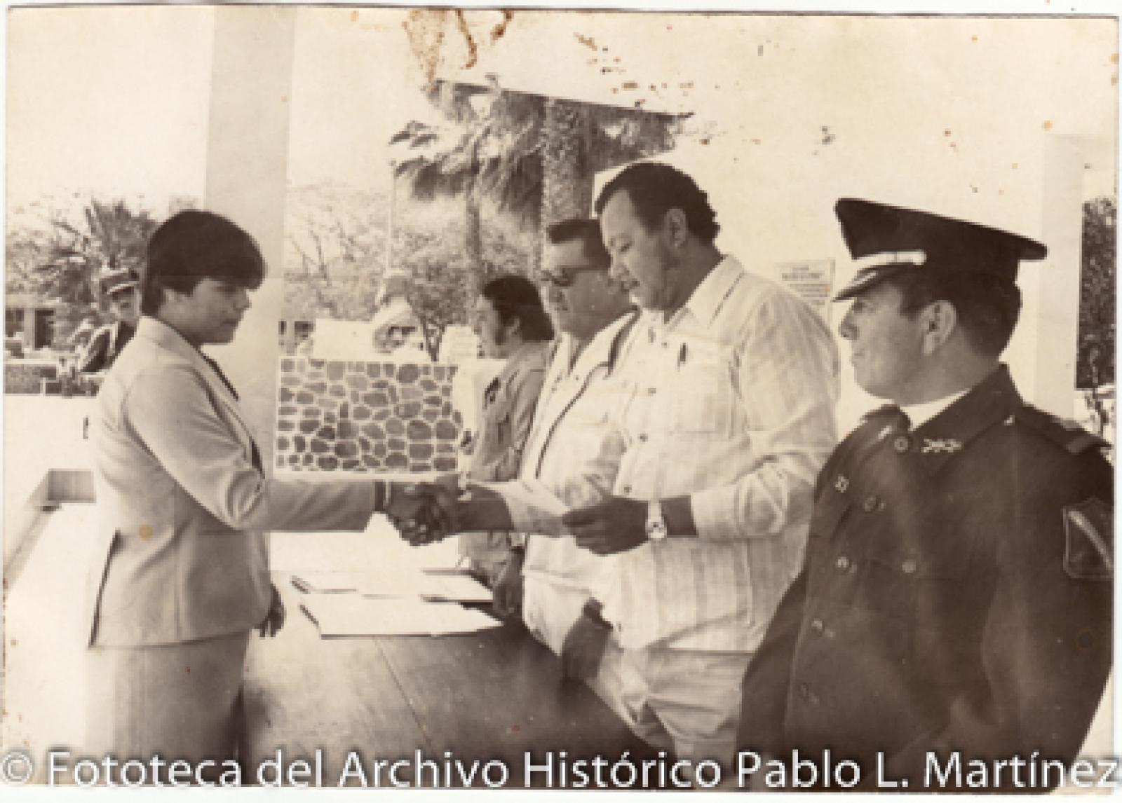 Militares y civiles en entrega de documentos.