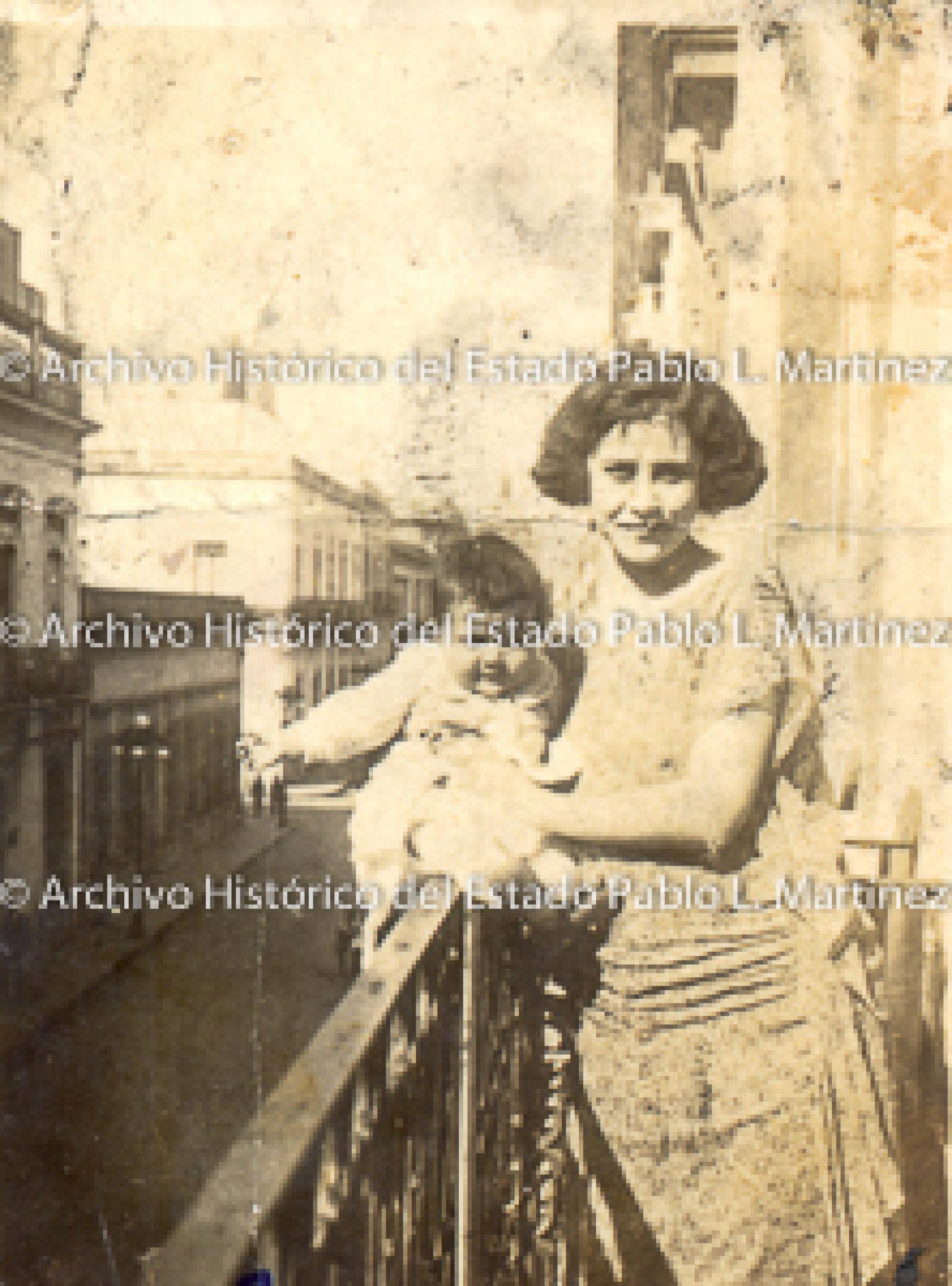 Mujer con bebe en balcón, retrato.