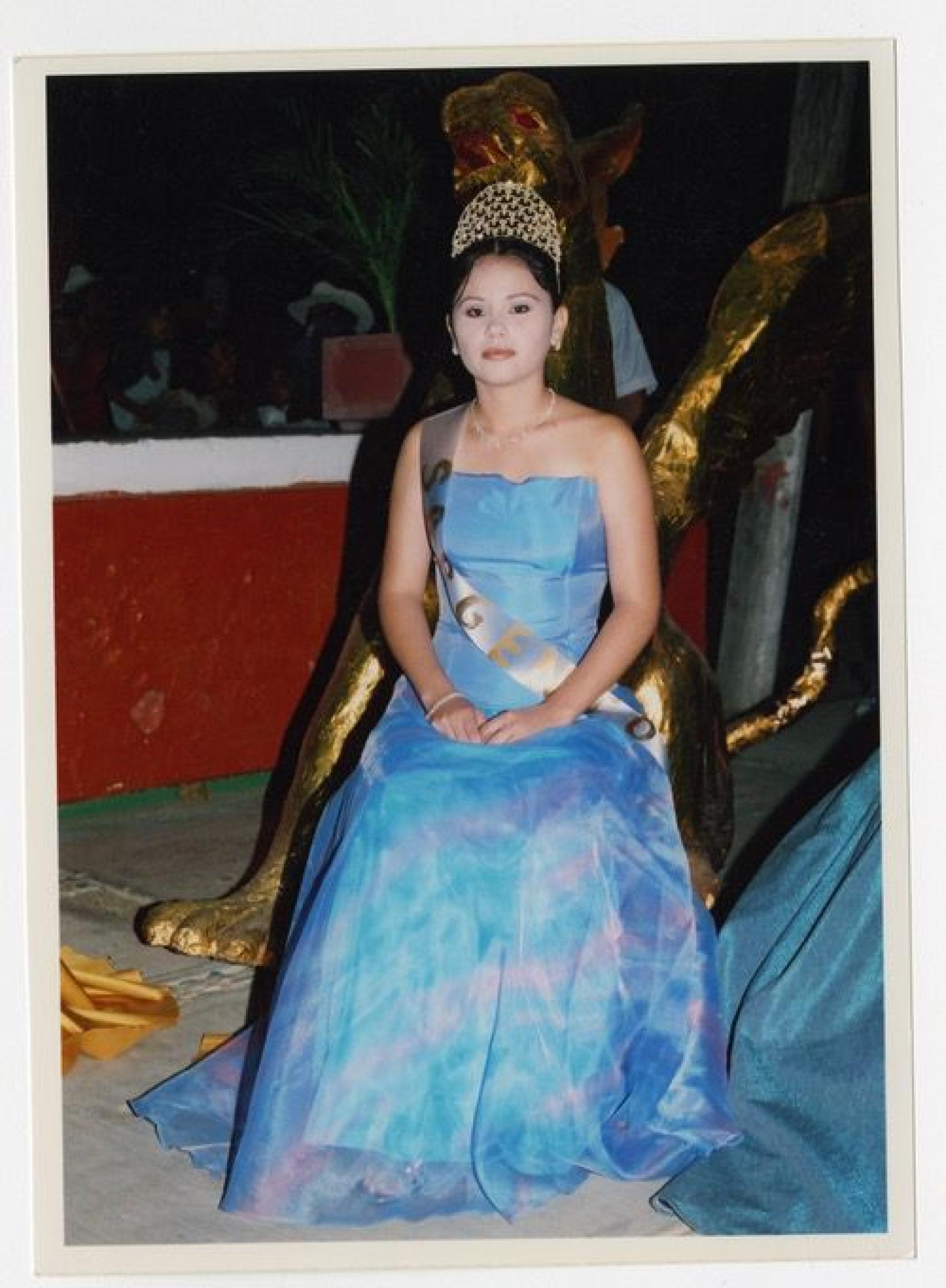 Mujer con vestuario de realeza en evento.