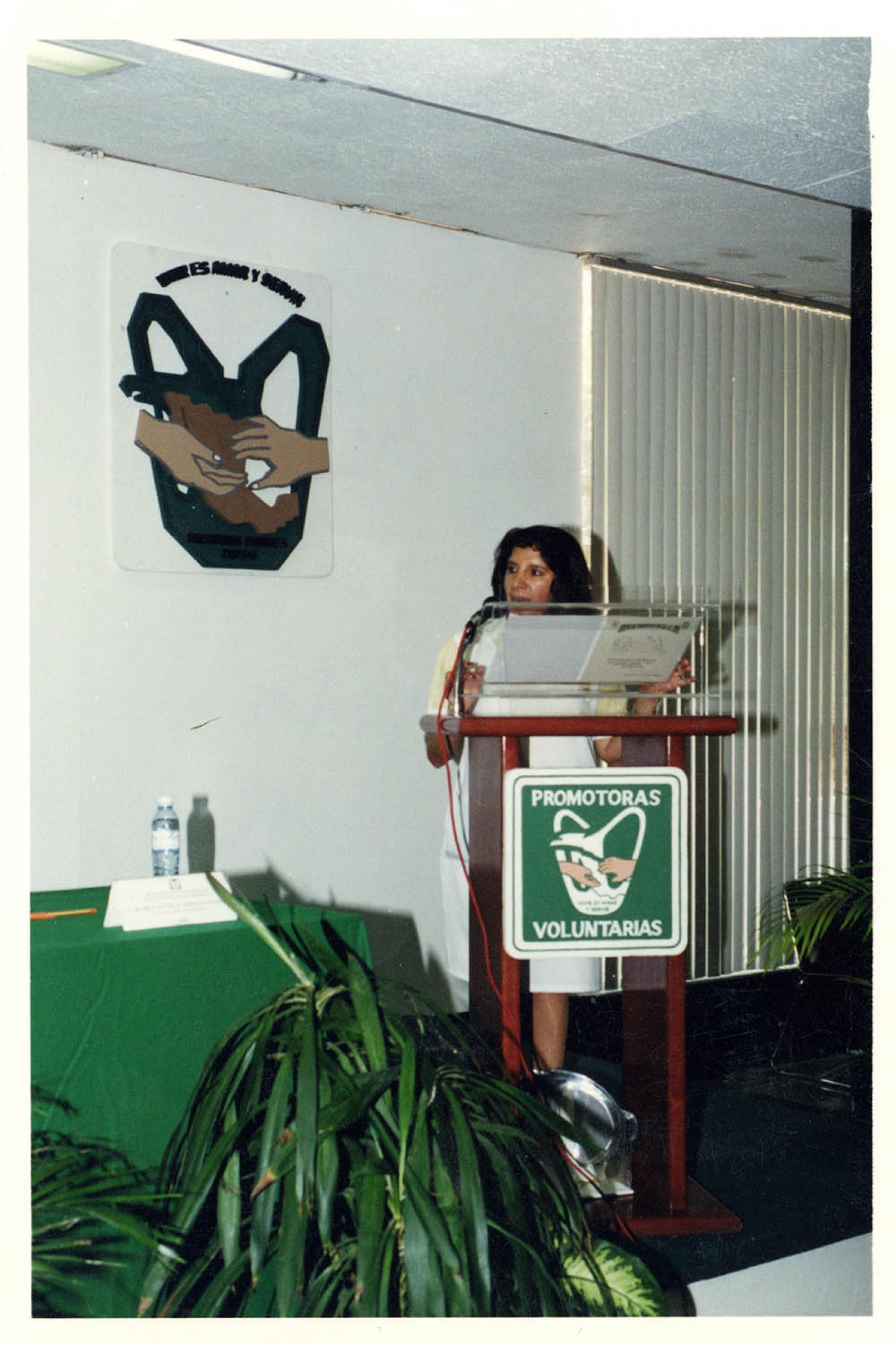 Mujer en evento de promotoras voluntarias de salud, retrato.