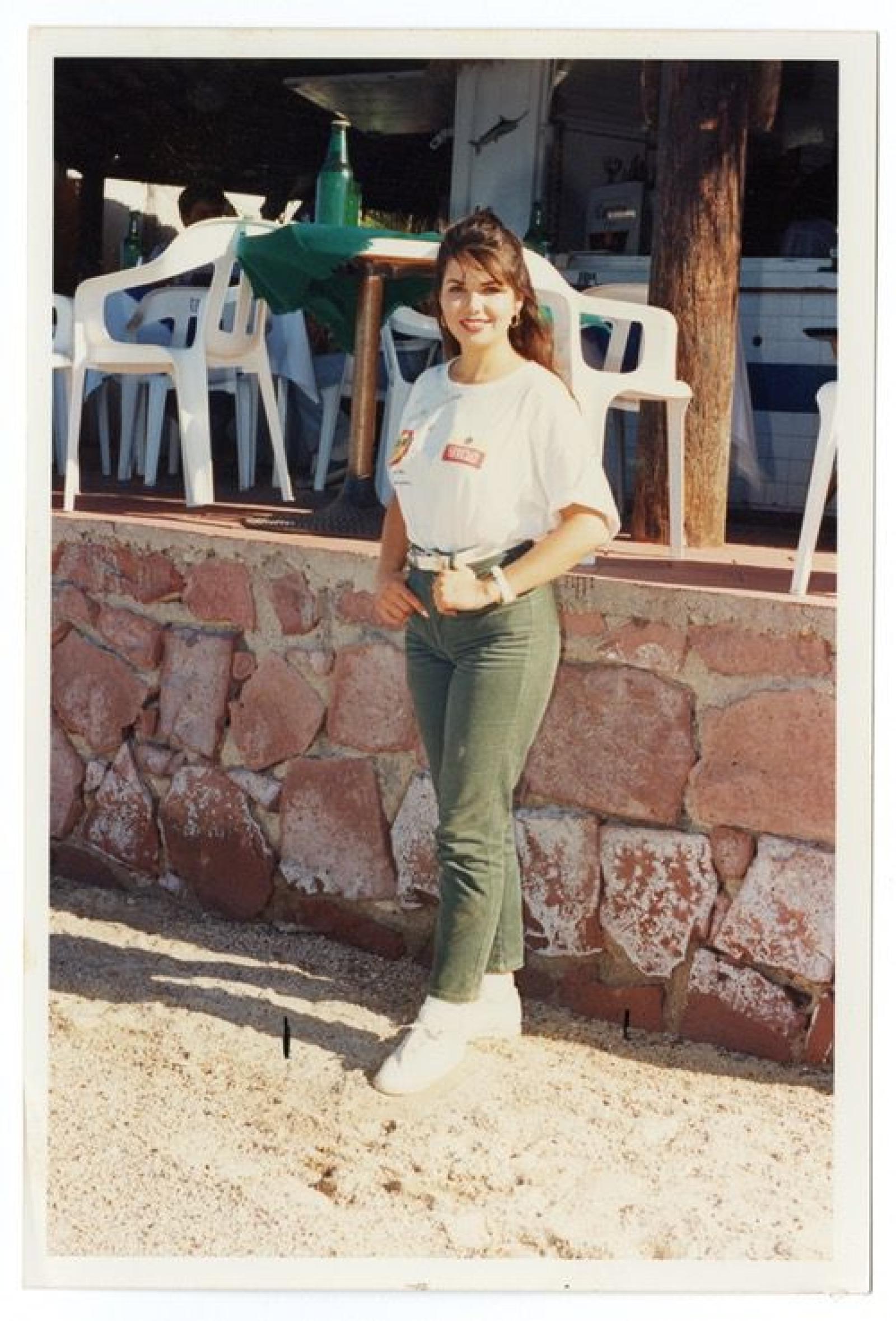 Mujer en pose frente a restaurante, retrato.