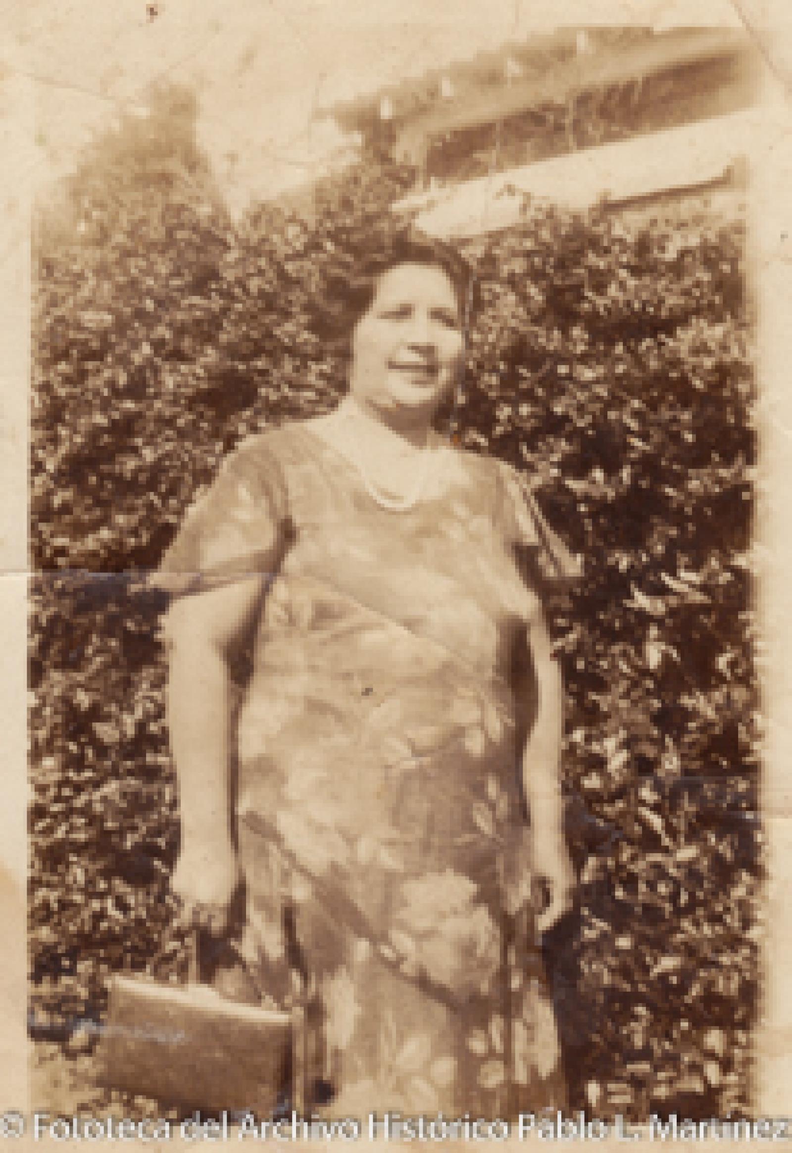 Mujer frente a arbustos.