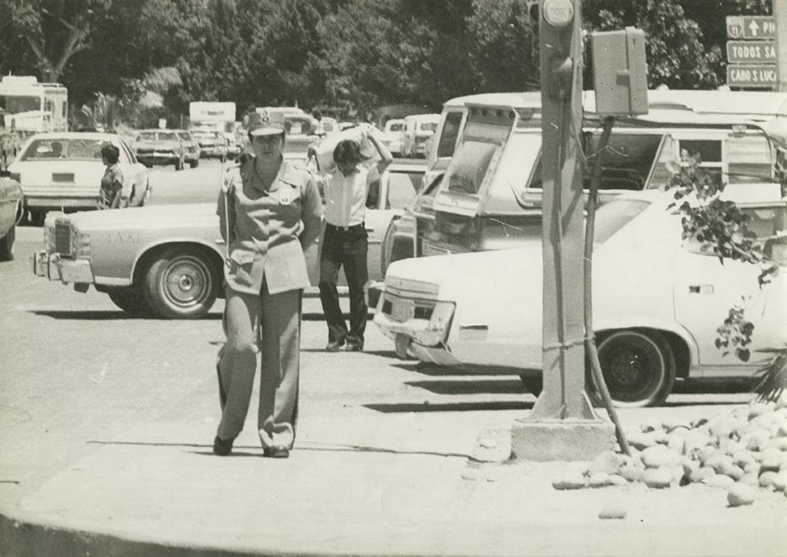 Mujer policía en calle transitada.