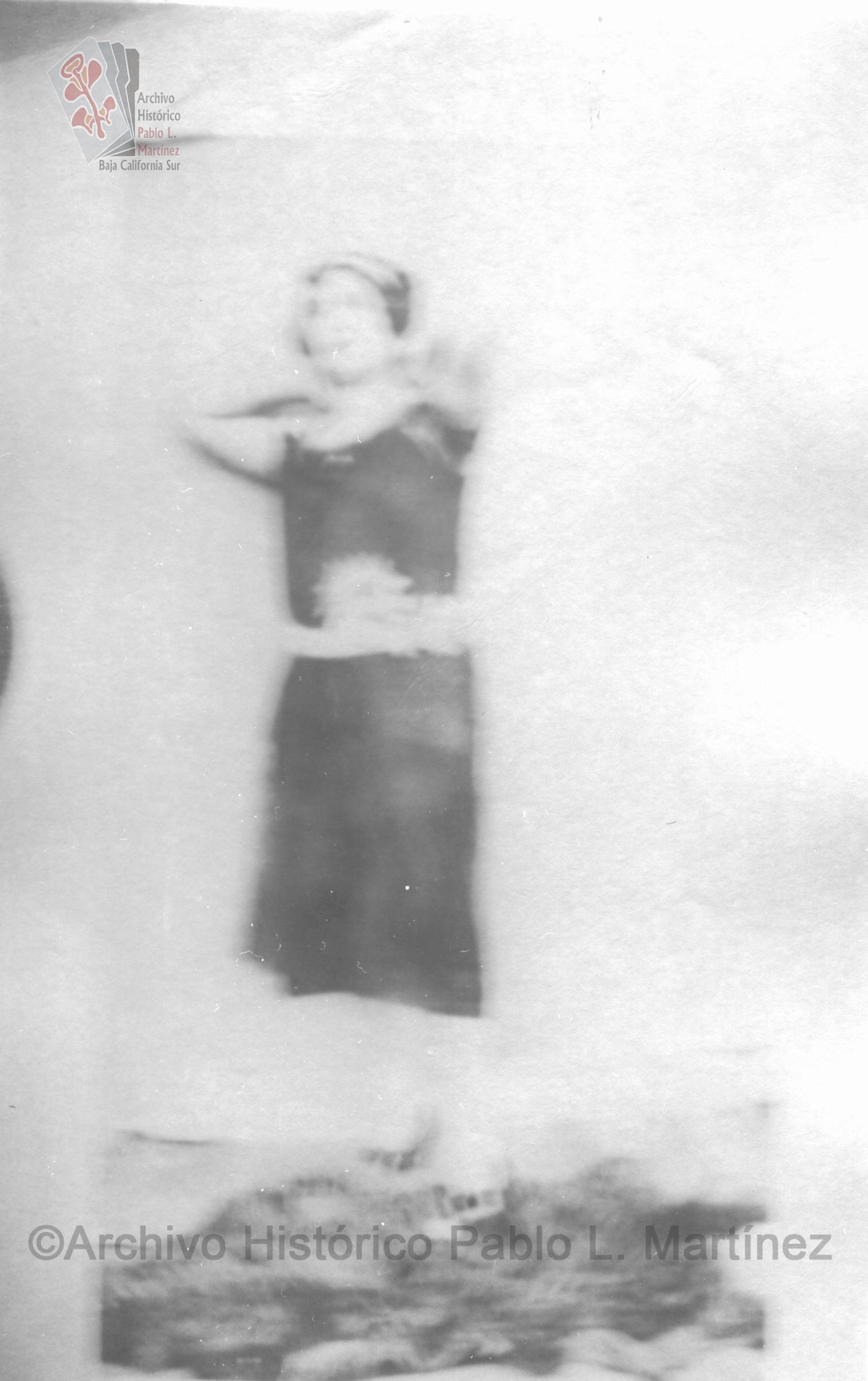 Mujer posa de pie con manos tras el cuello.