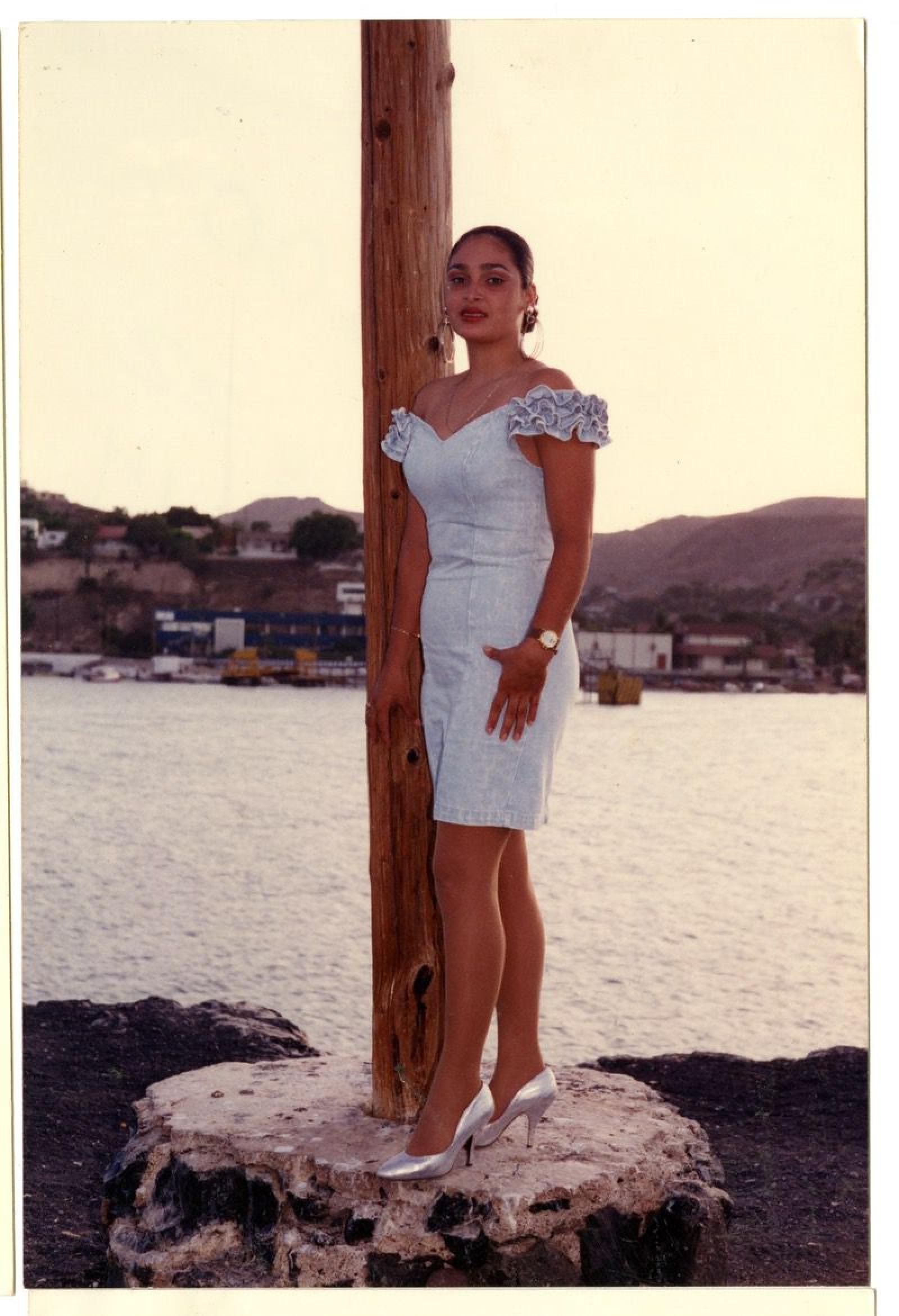 Mujer posando en paisaje marítimo.