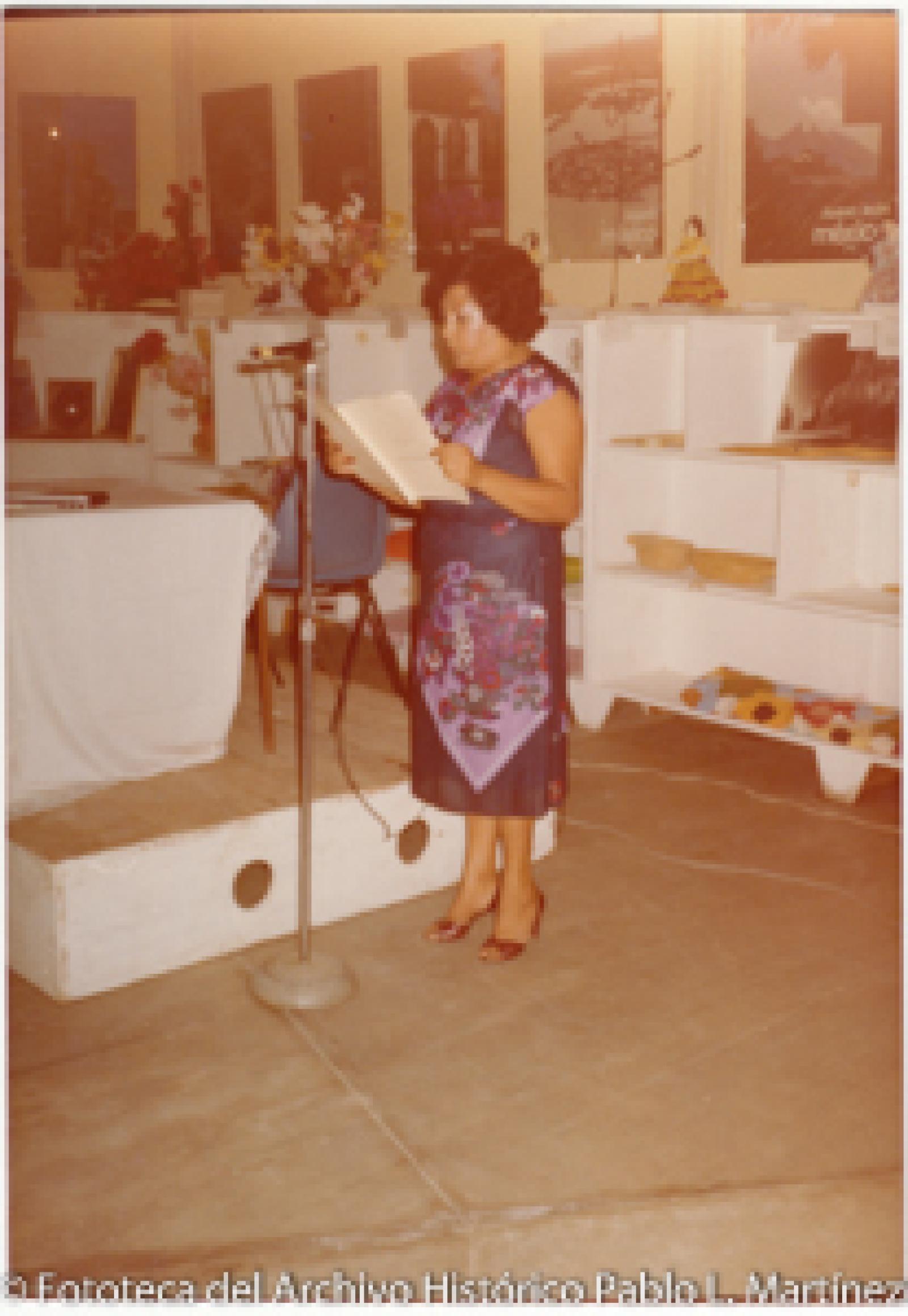 Mujer que lee frente a micrófono.