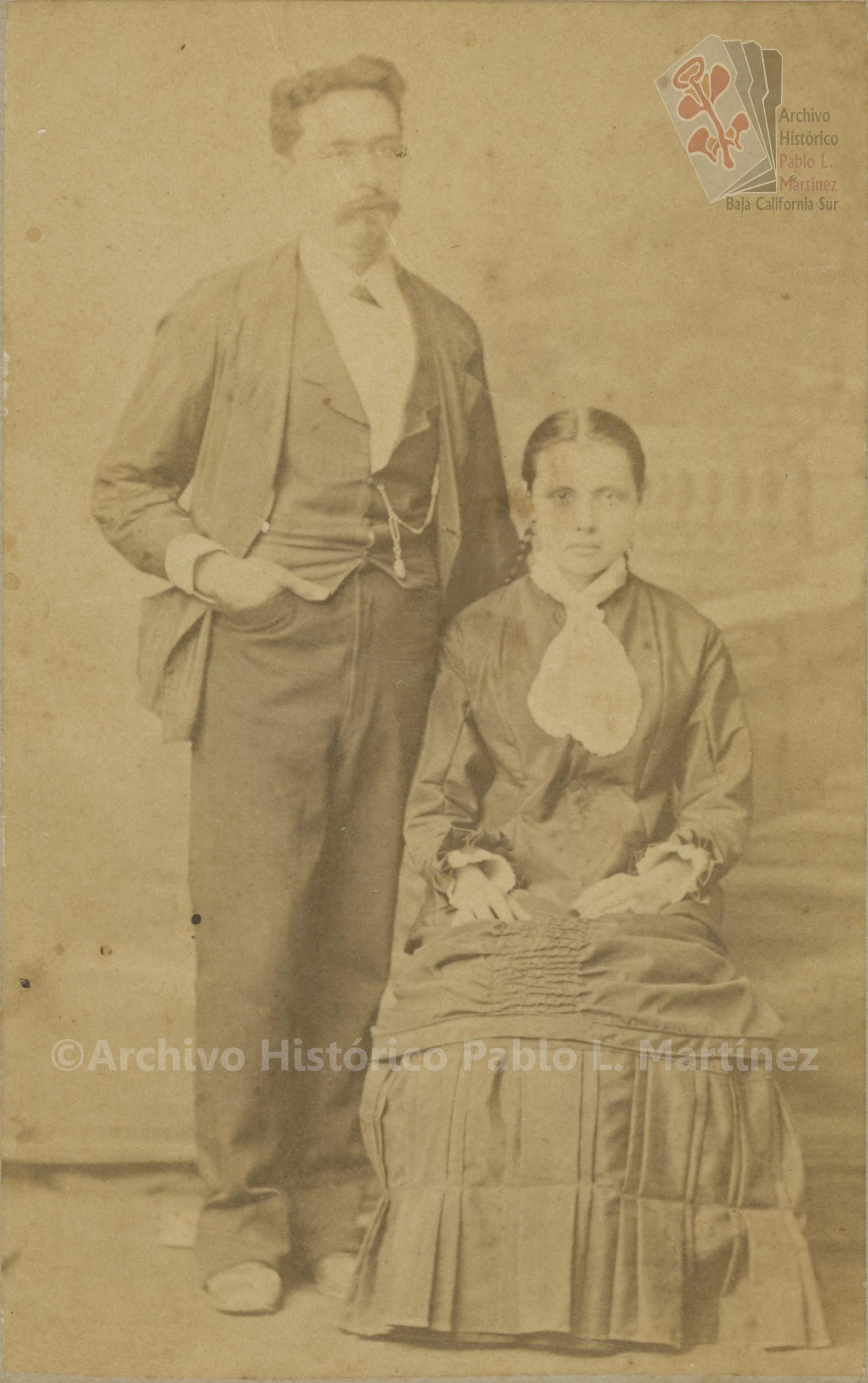 Mujer que posa sentada y, hombre que posa de pie junto a ella, retrato.