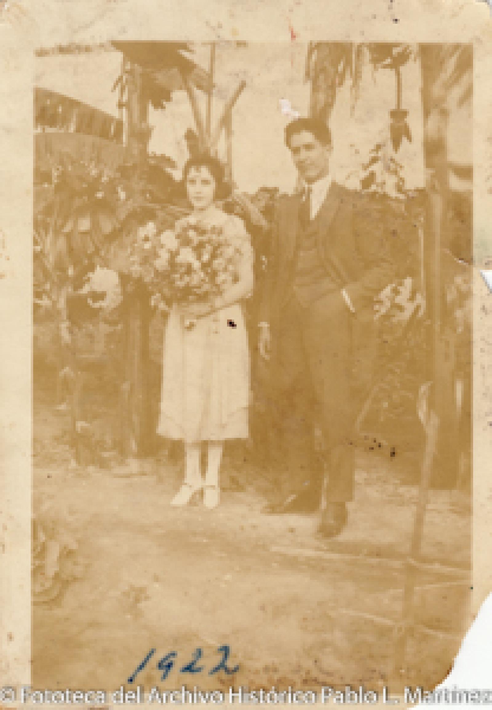 Mujer que sostiene ramo de flores al lado de hombre.