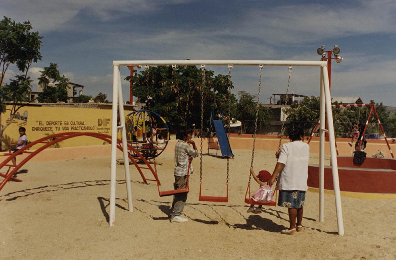 Mujer y niños en parque público.