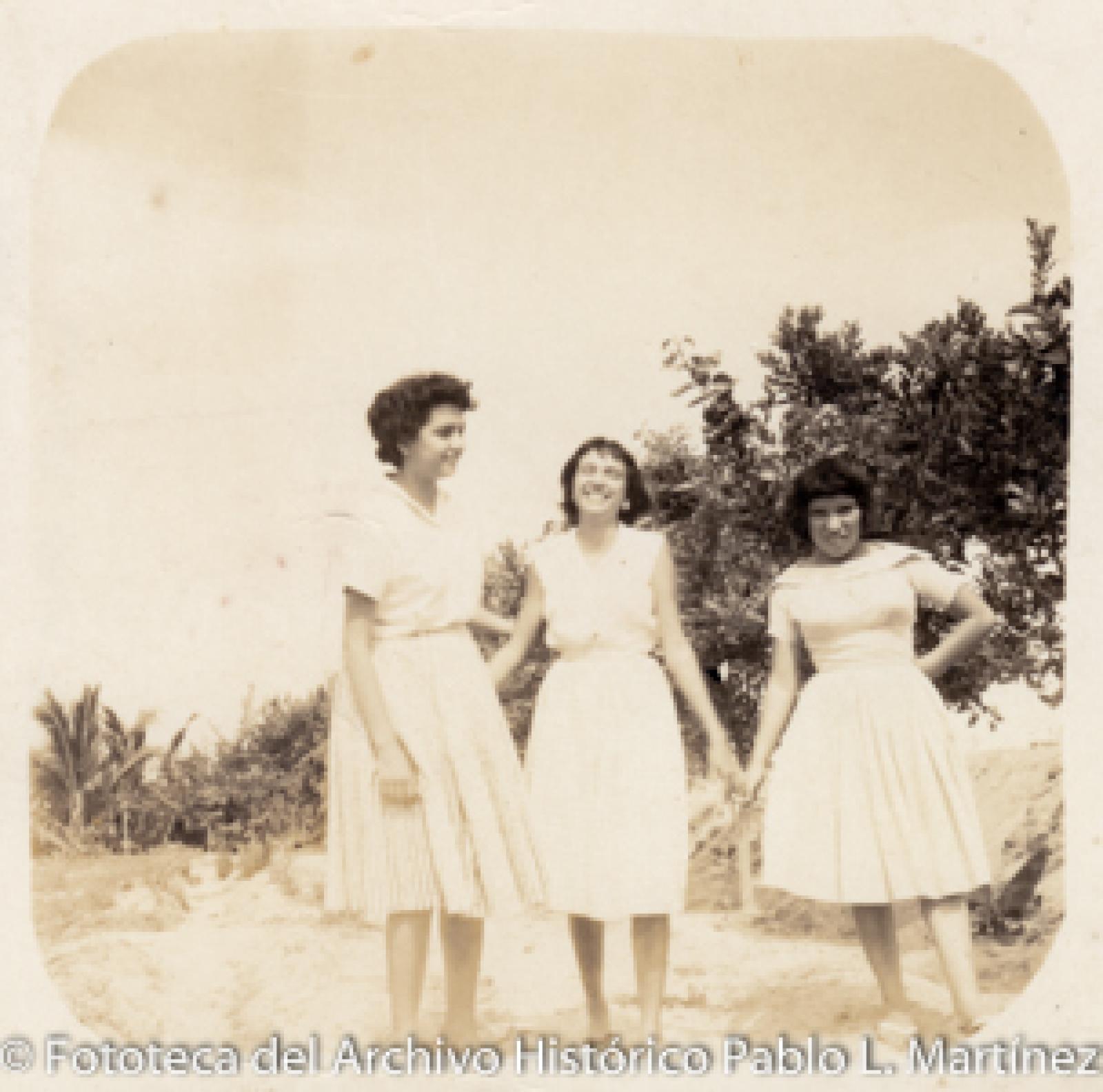 Mujeres, árboles y palmeras.