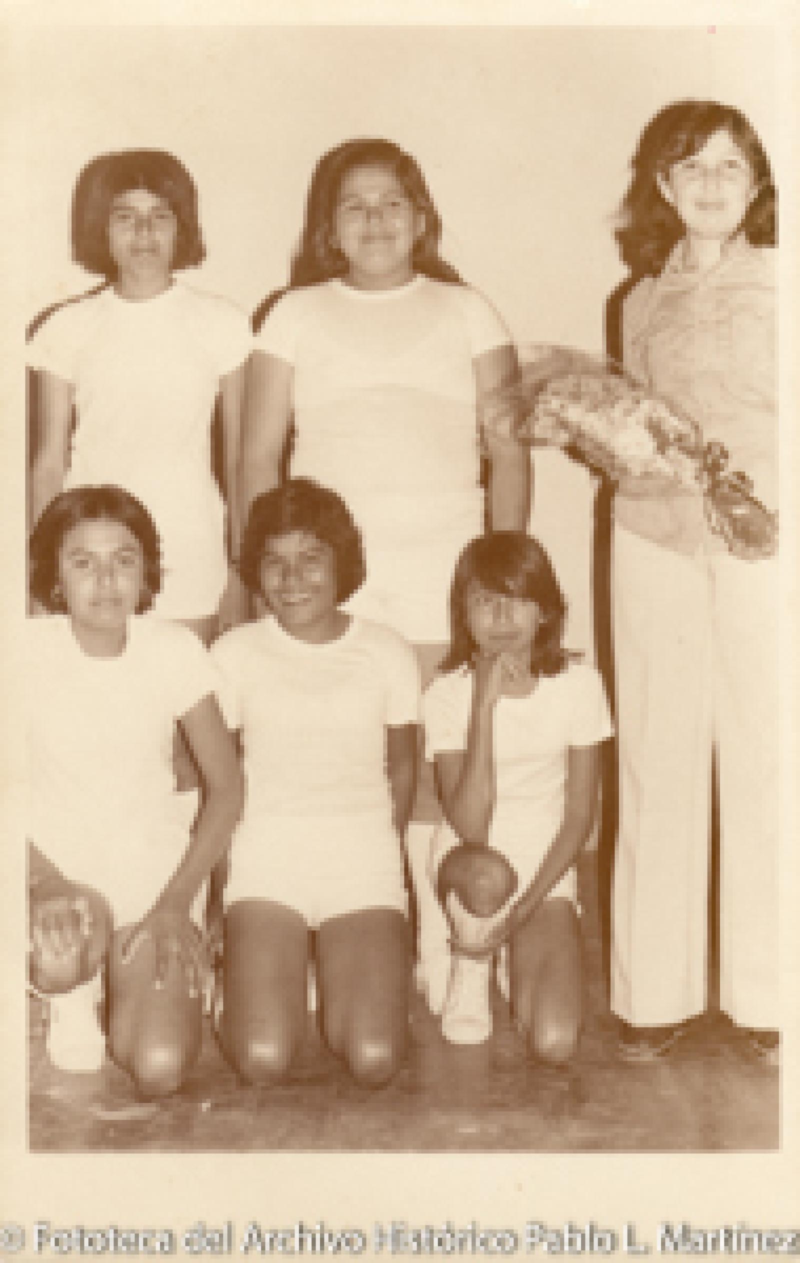 Mujeres con uniforme deportivo al lado de mujer con ramo