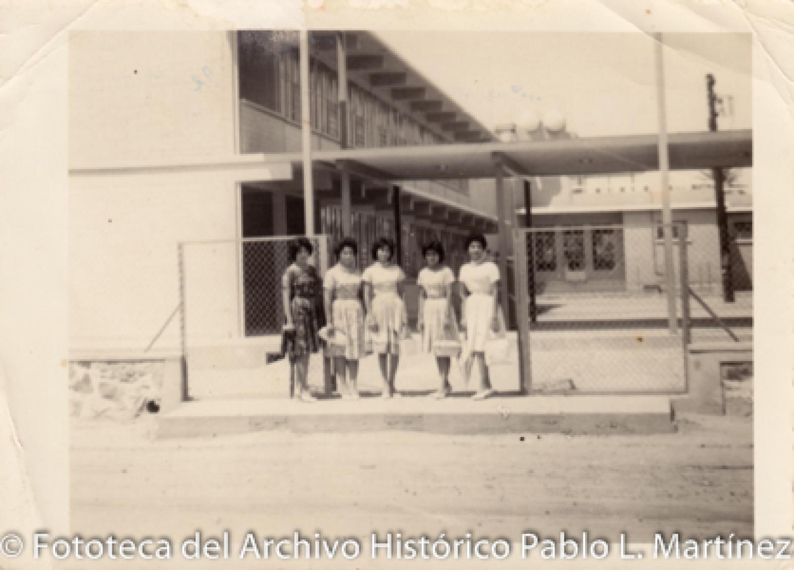 Mujeres frente a edificio escolar