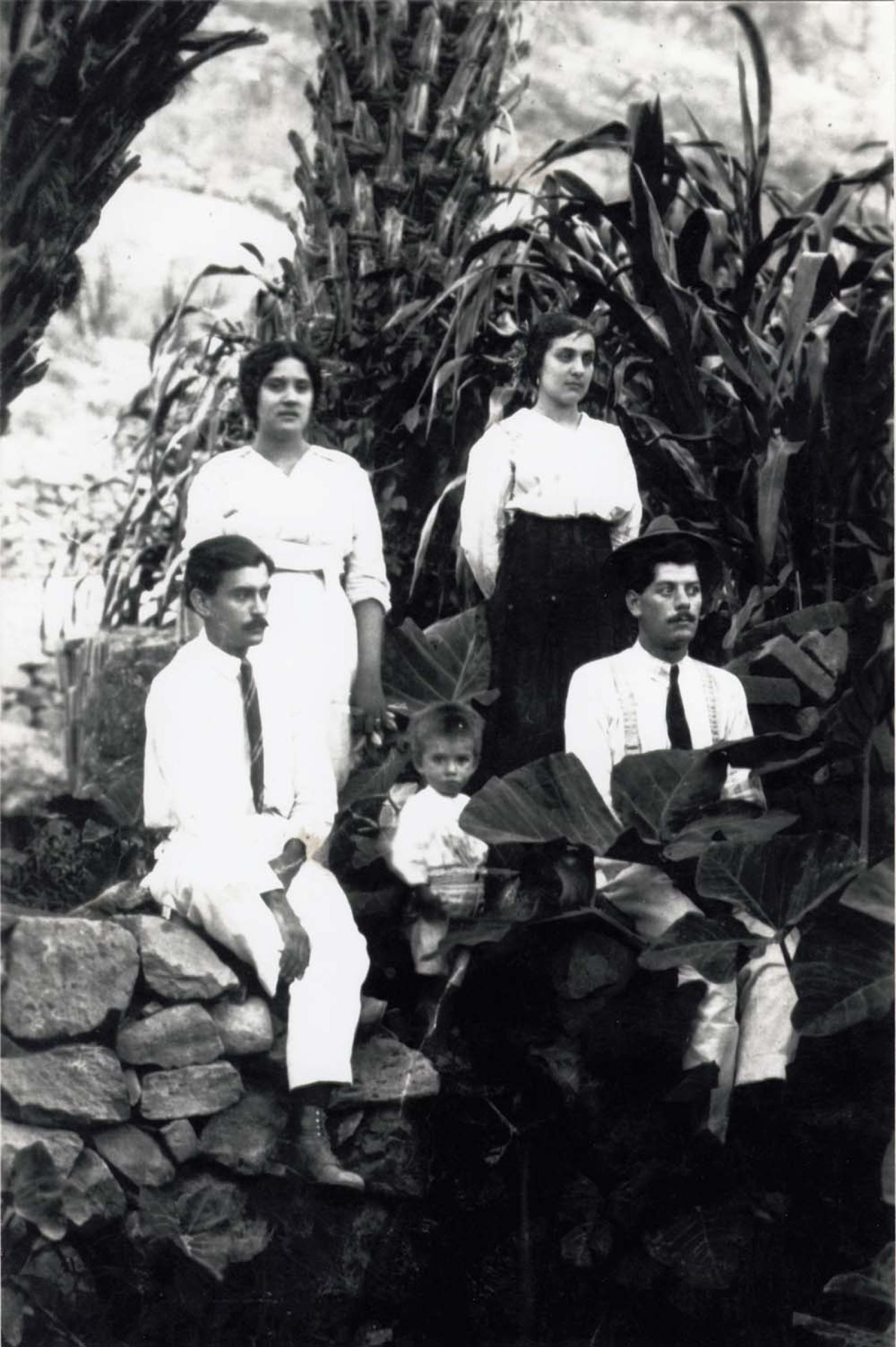 Mujeres, hombres y niño en jardín, retrato de grupo.