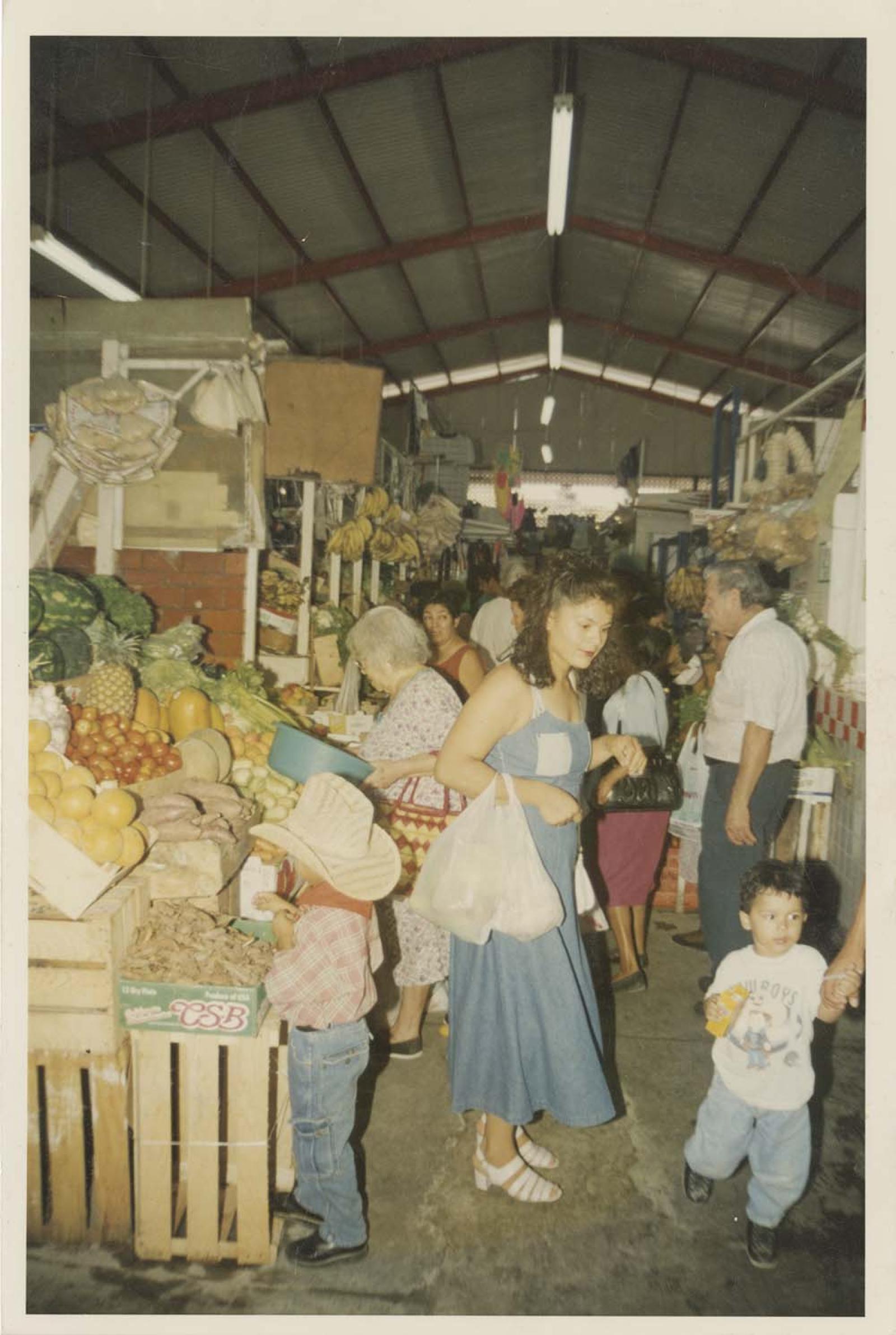 Mujeres, hombres y niños en mercado.