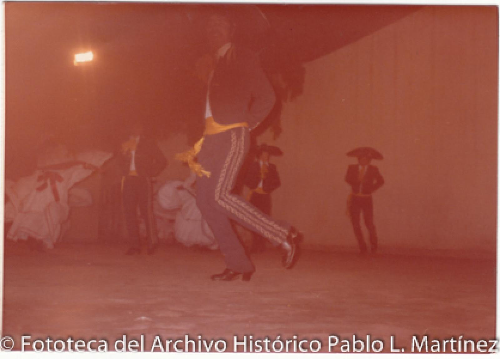 Mujeres que bailan con hombres que visten de charro.