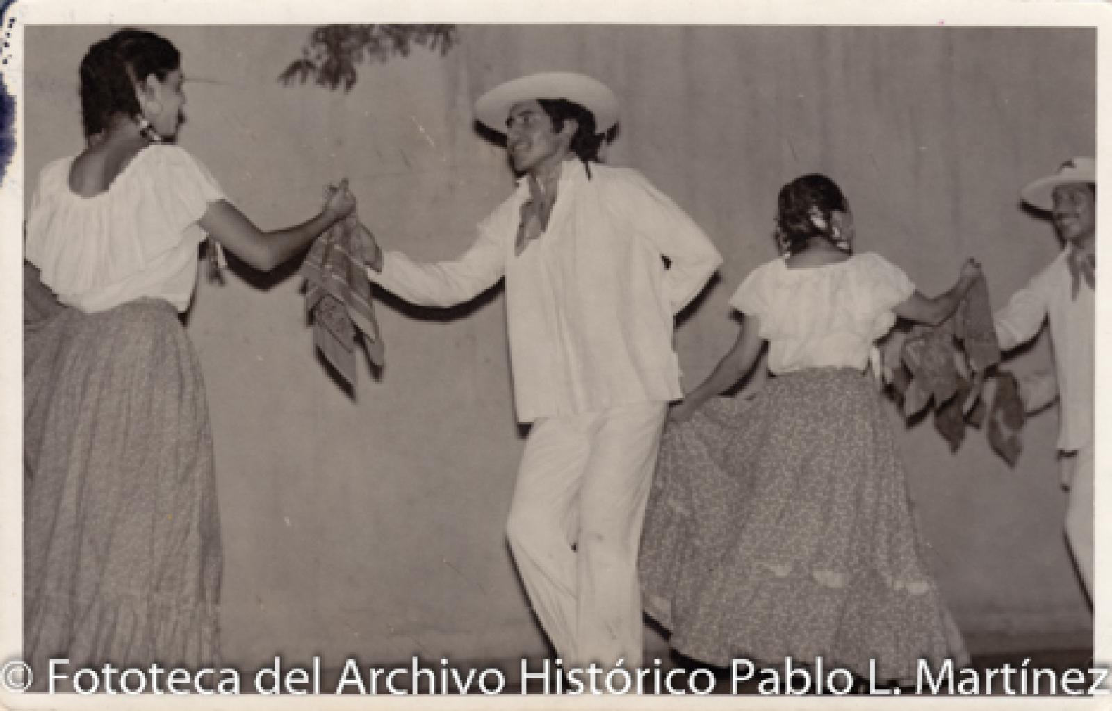 Mujeres que bailan con veladoras sobre sus cabezas.