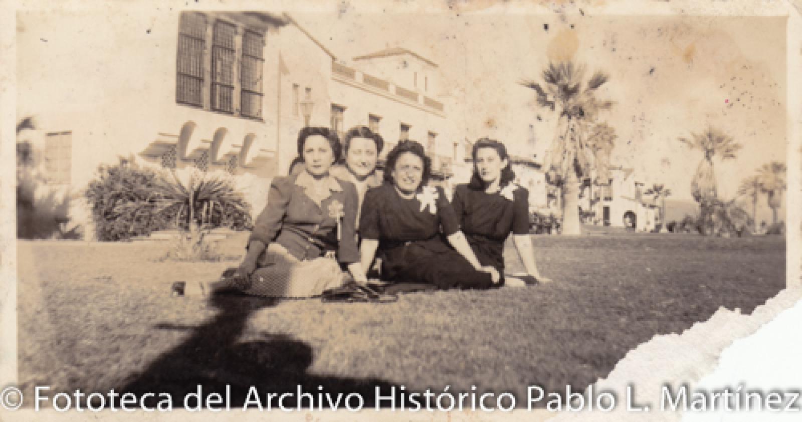 Mujeres sentadas en césped.