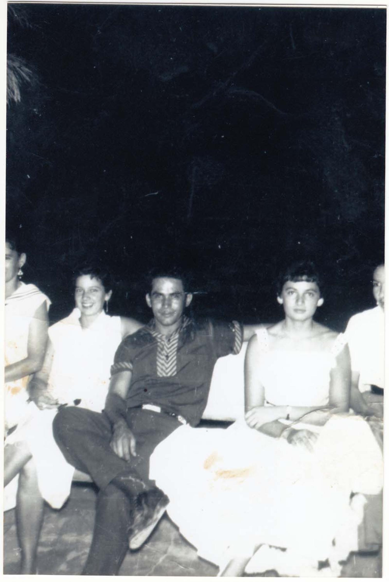 Mujeres y hombre en una banca, retrato de grupo.