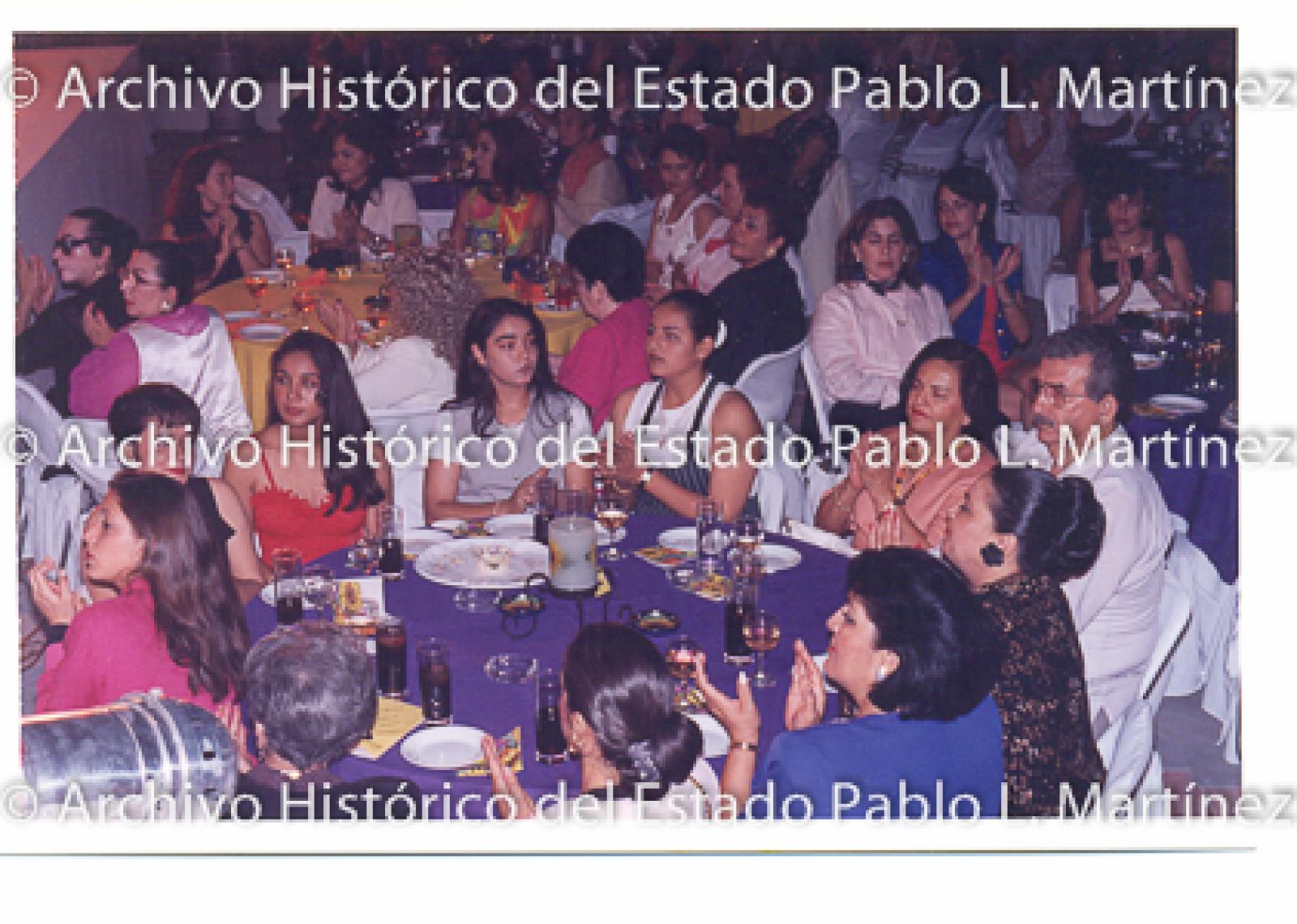 Mujeres y hombres aplauden en evento público.