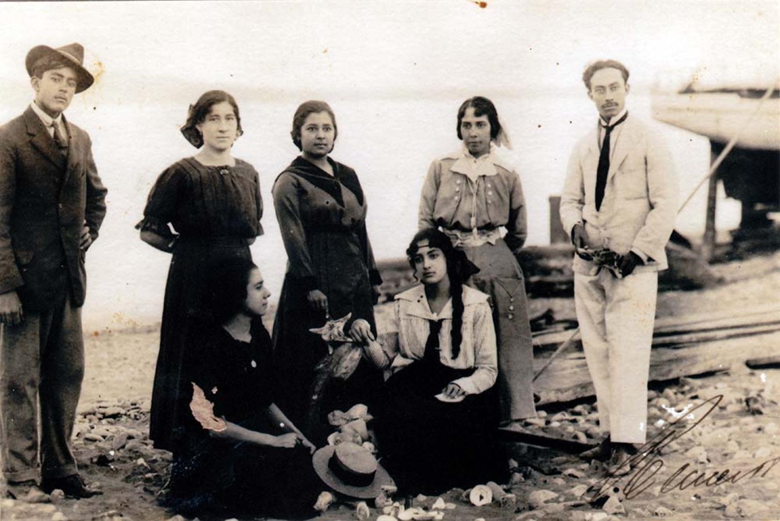 Mujeres y hombres en la playa, retrato de grupo.
