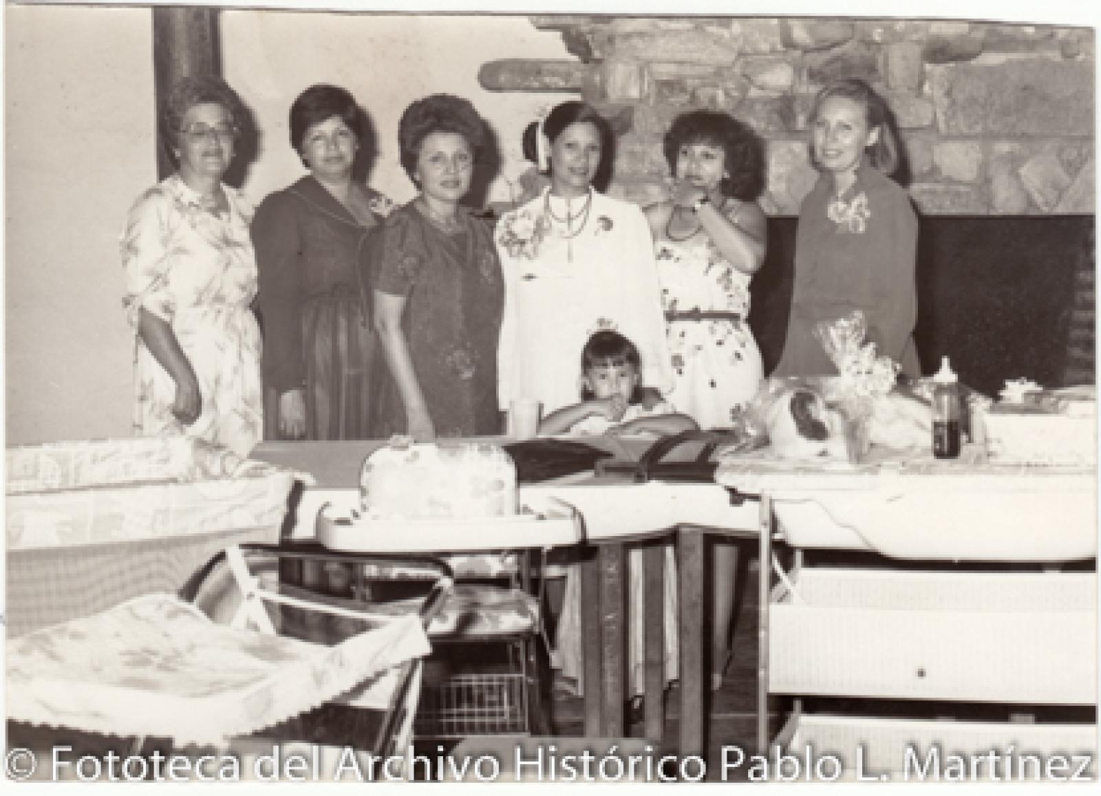 Mujeres y niña junto a accesorios para bebé. .
